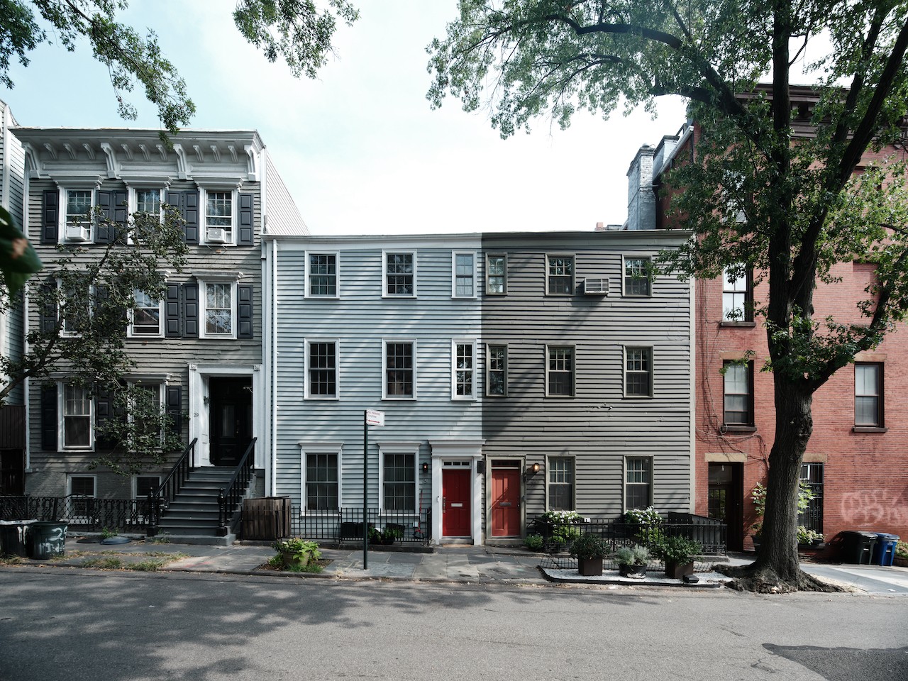 A row of houses on a city street with a red door.