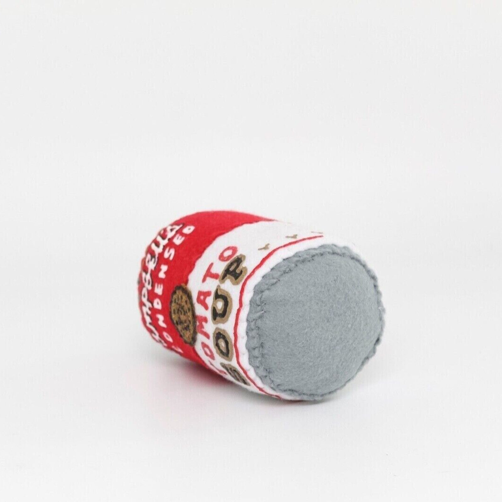 A stuffed toy of a can of soup with a cookie on it.