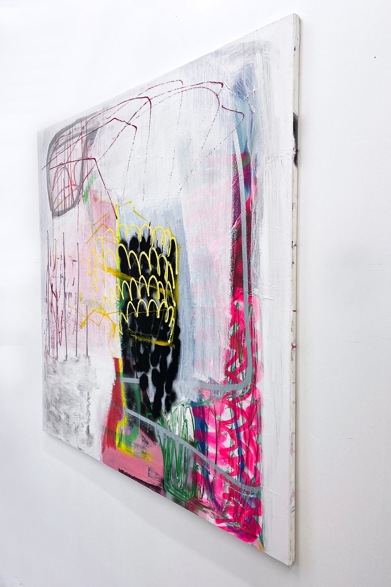 A painting on a white wall with a black and yellow design.
