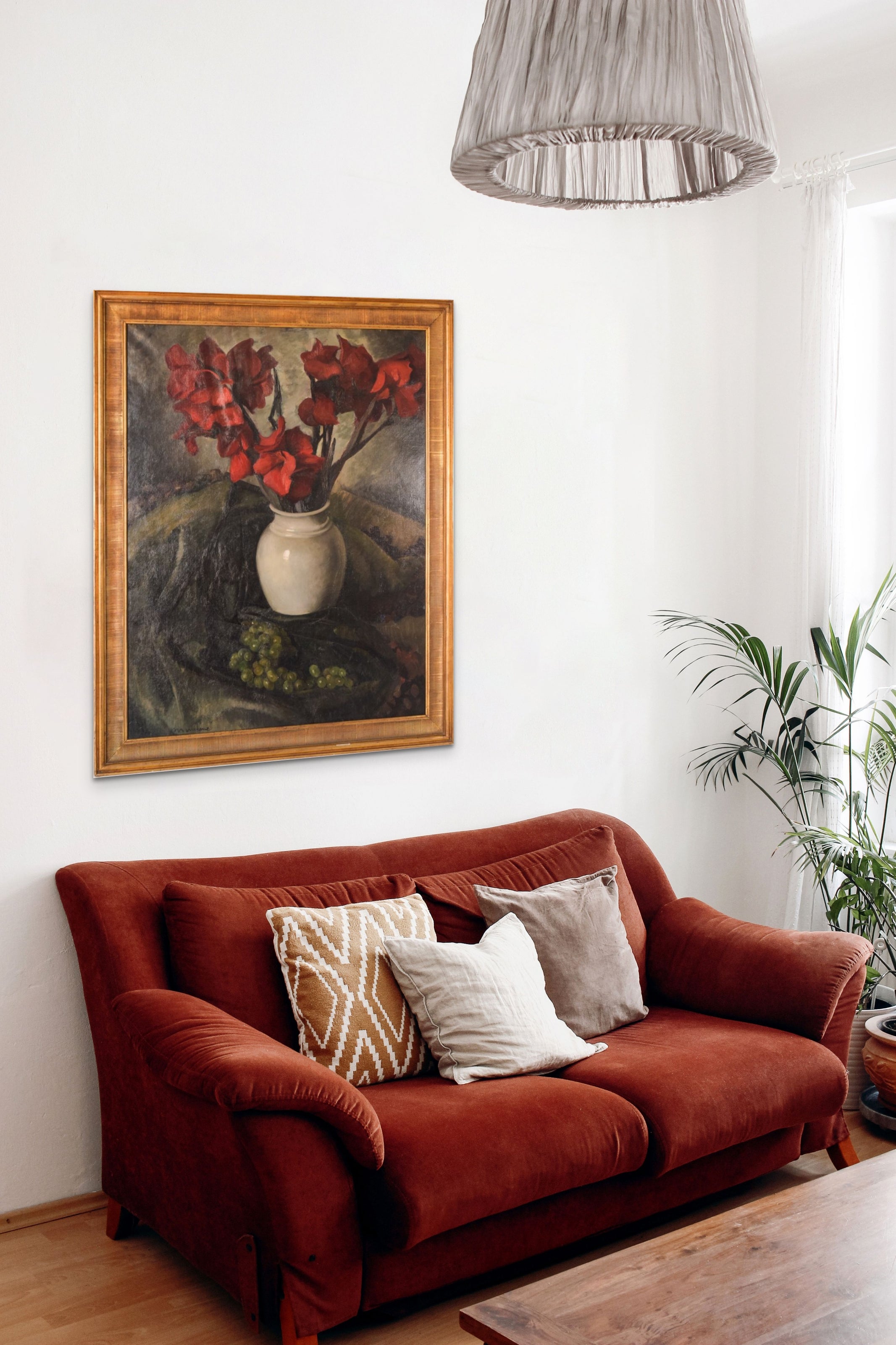 A painting of red flowers in a white vase on a table.