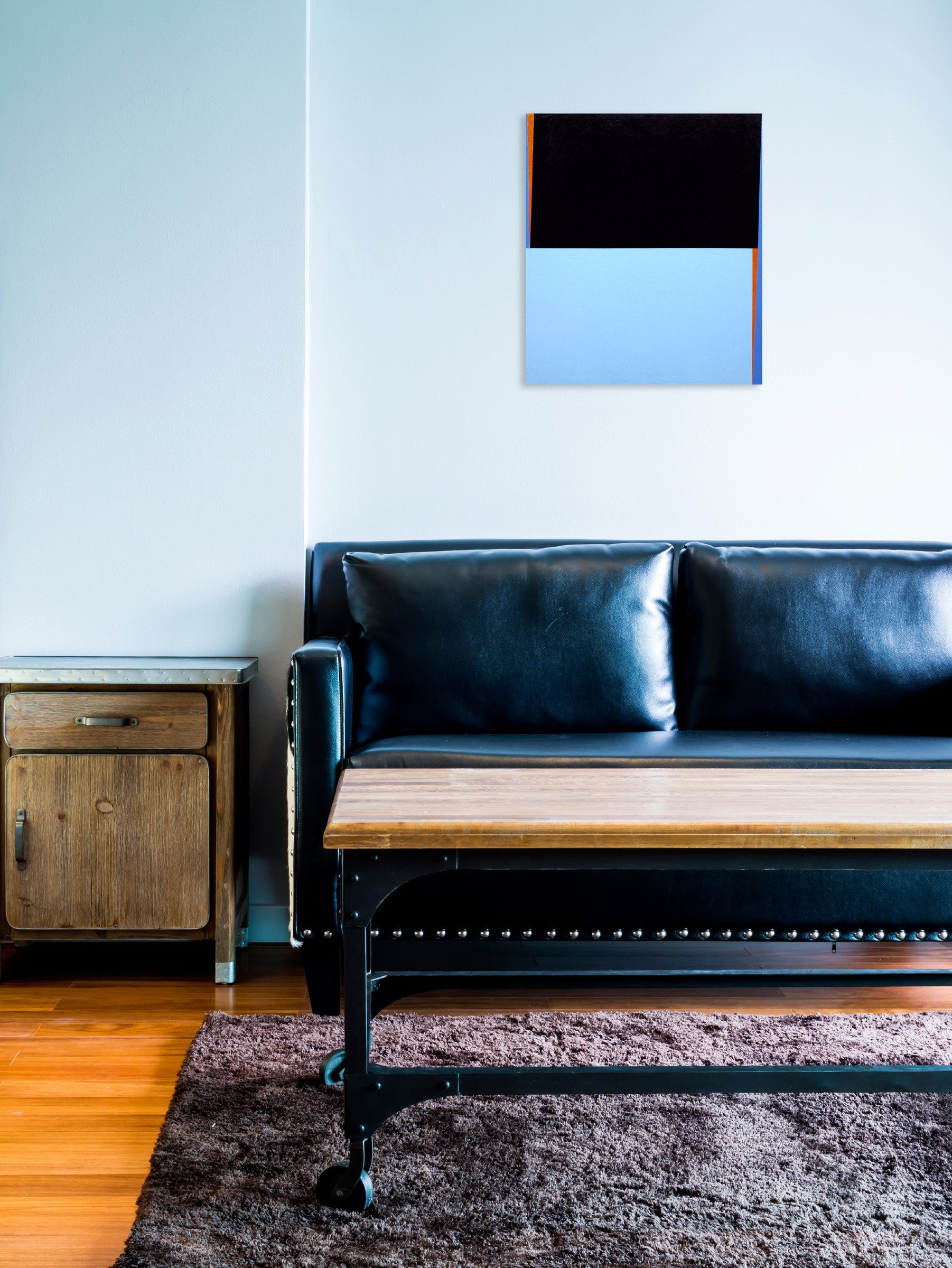 A black and blue painting on a white wall.