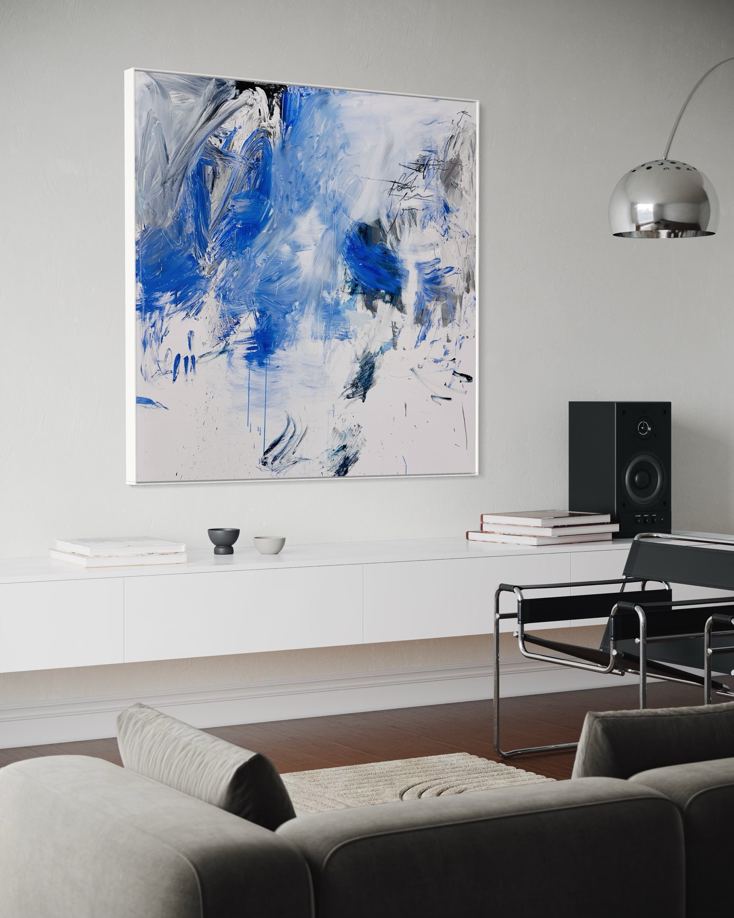 A blue and white abstract painting on a white wall.