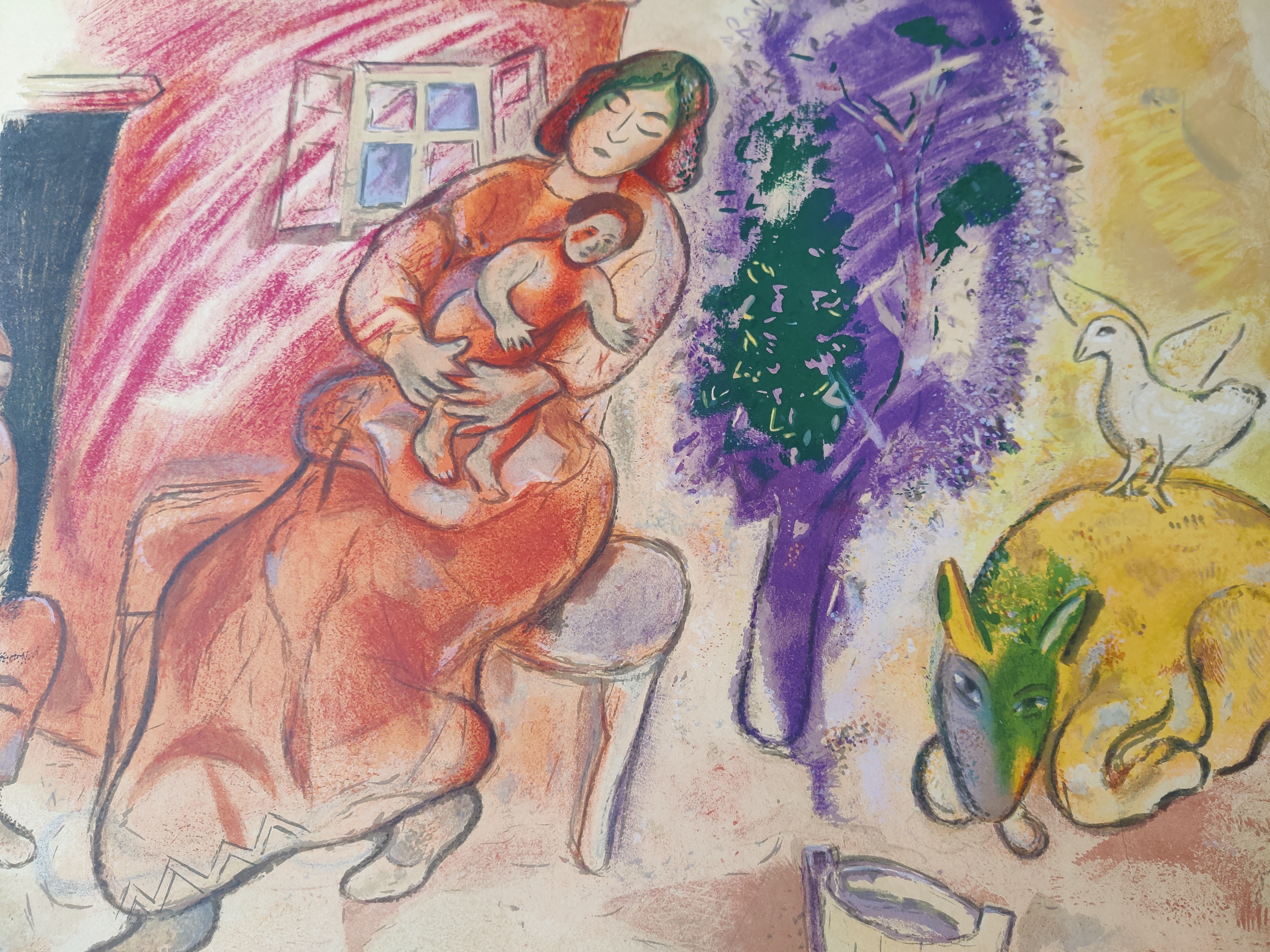 A colorful print of a seated figure holding a baby, surrounded by animals and vibrant abstract shapes.