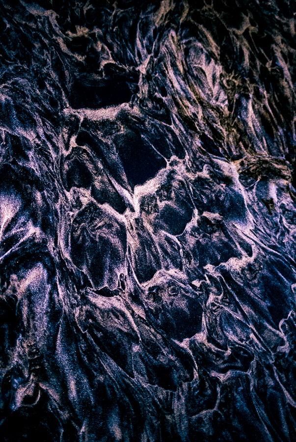 A close up of a black and purple marble surface.