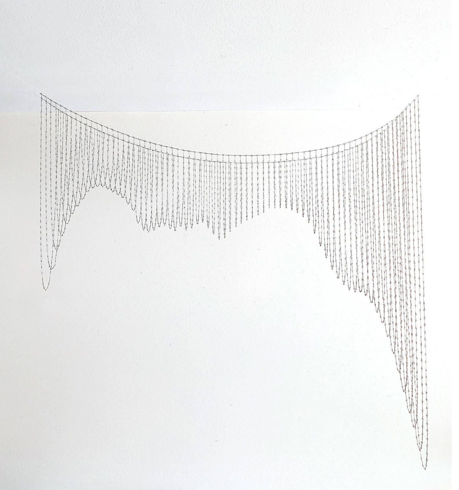 A drawing of a string of beads hanging from a wall.