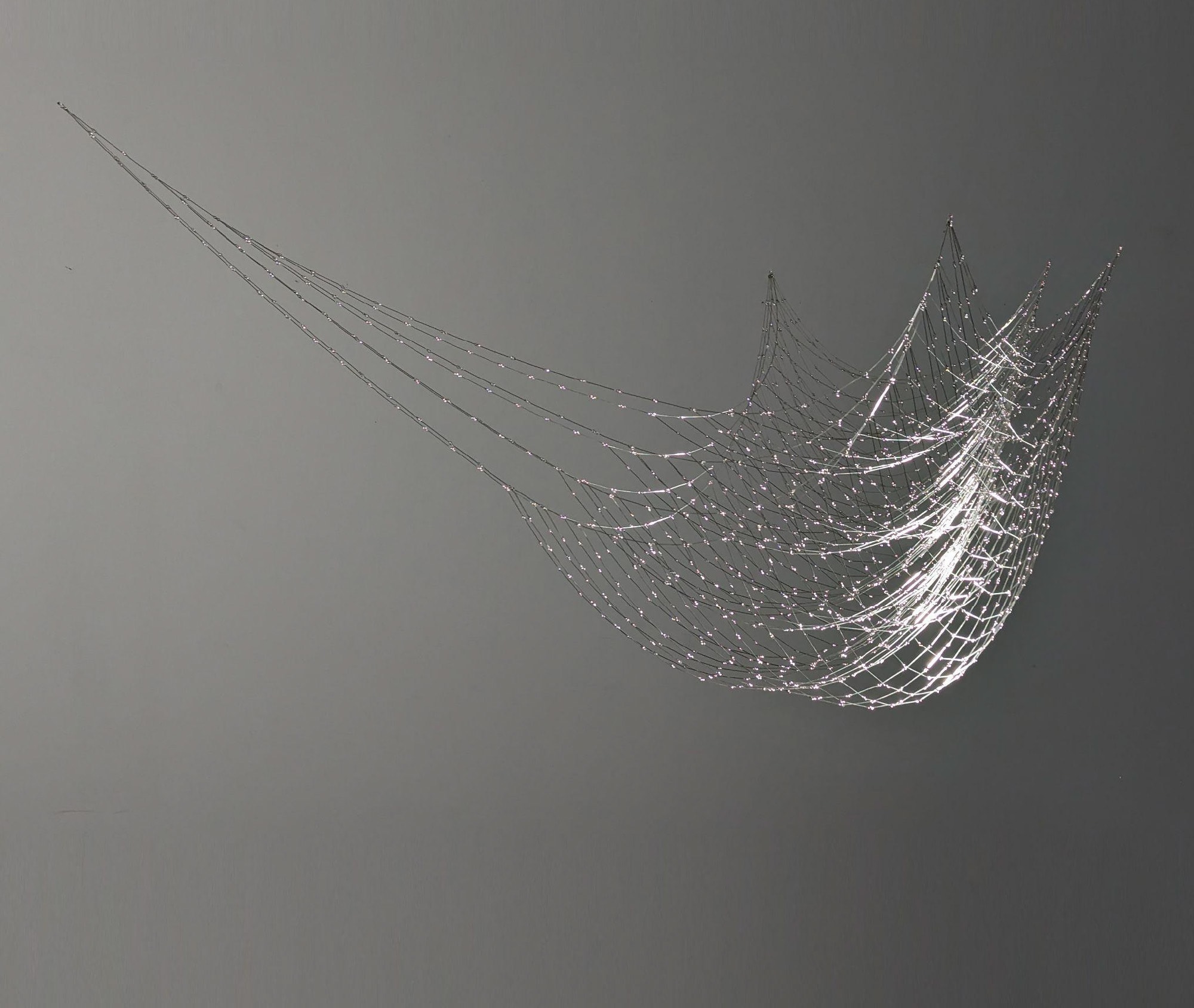 A spider web on a gray background. 