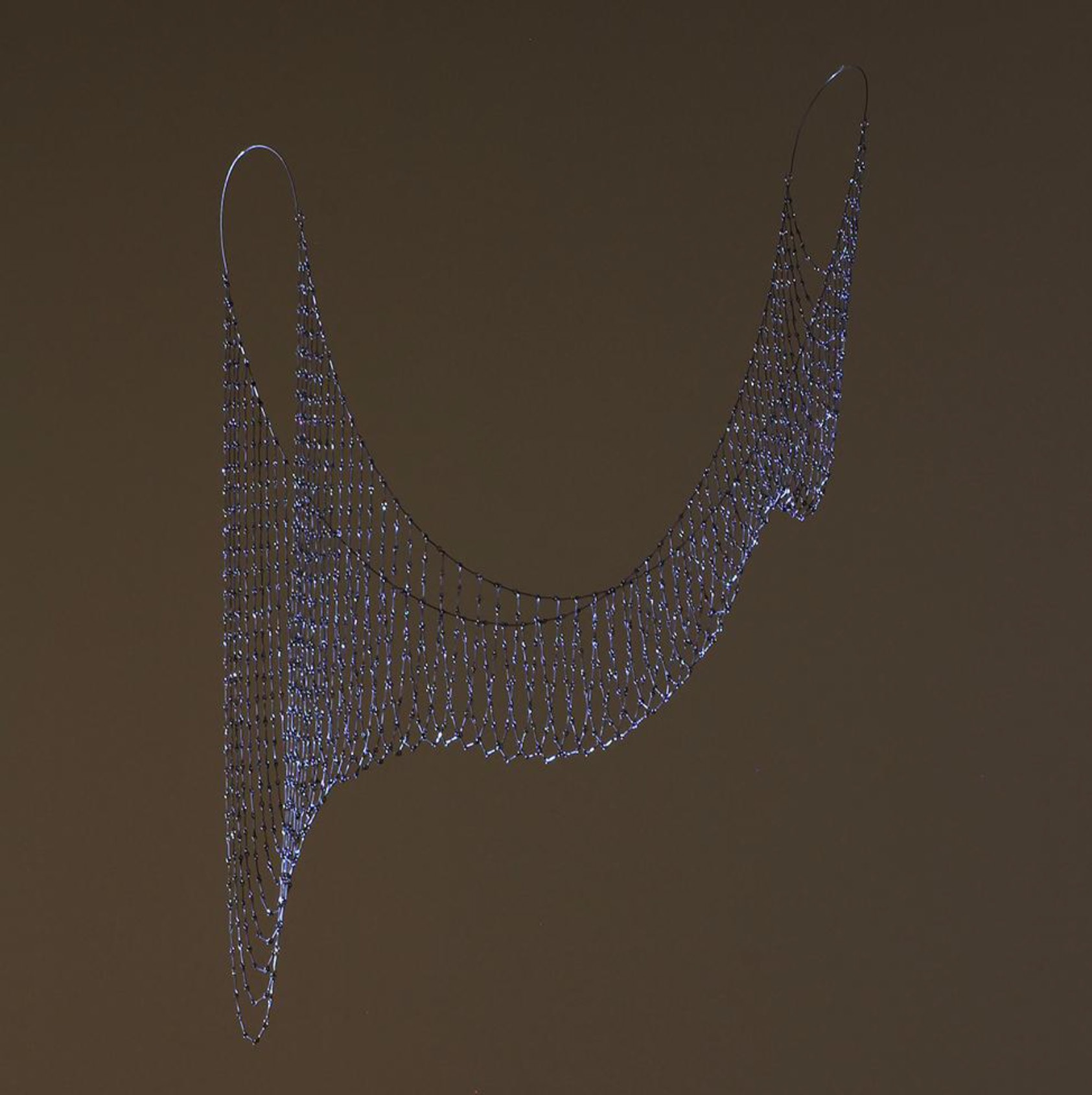 A 3D rendering of a wire sculpture on a brown background.