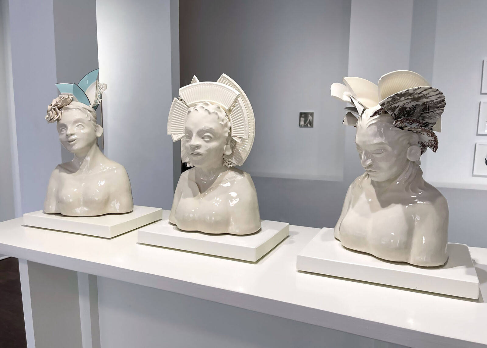 A glossy ceramic bust of a figure with an elaborate, segmented crown-like headpiece.