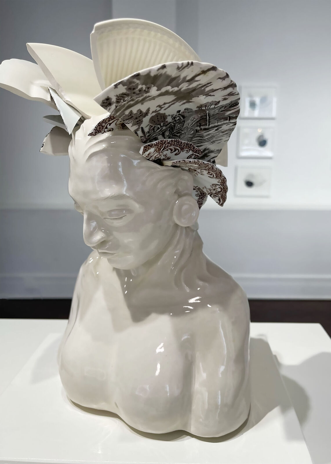 A ceramic bust adorned with broken porcelain fragments forming a headdress.