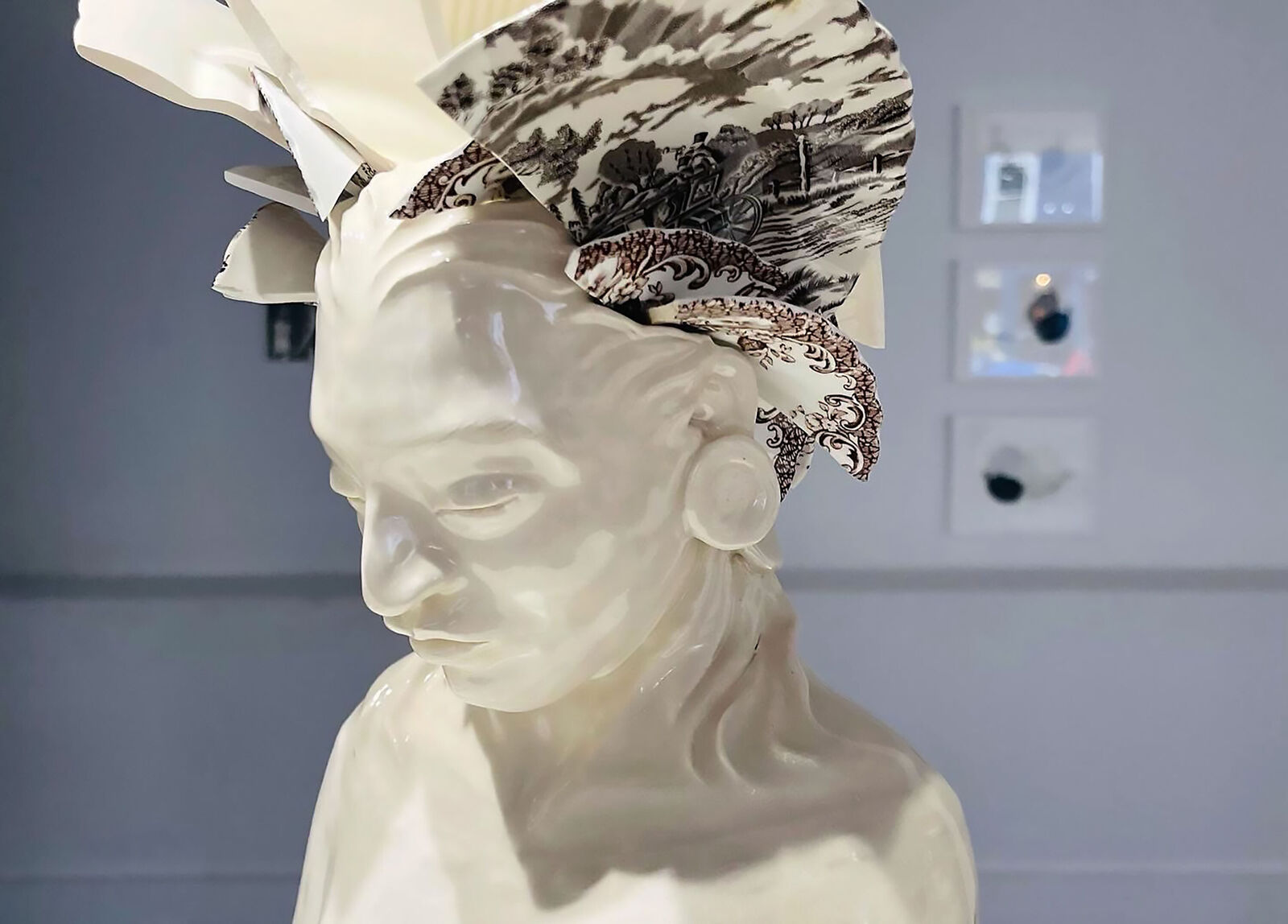 A ceramic bust adorned with broken porcelain fragments forming a headdress.