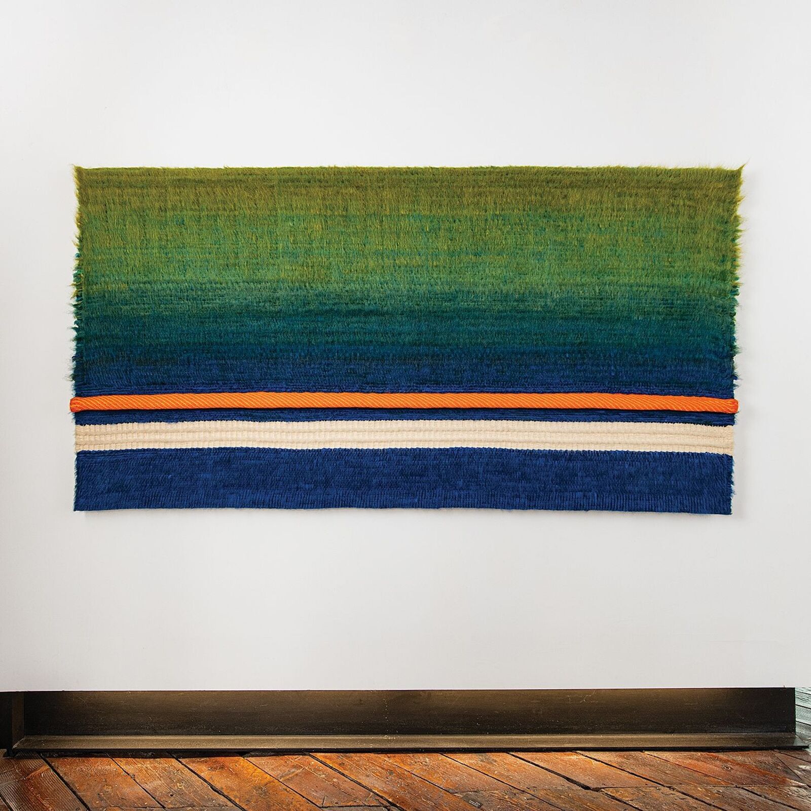 A woven textile featuring a vertical gradient from green to blue with horizontal stripes.