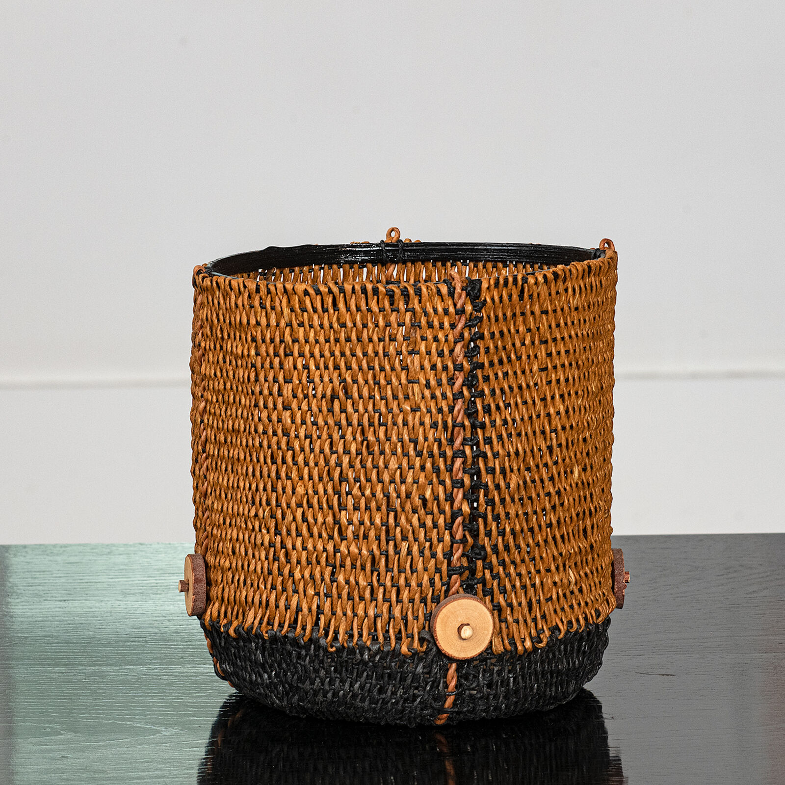 A black and orange basket sitting on top of a table.