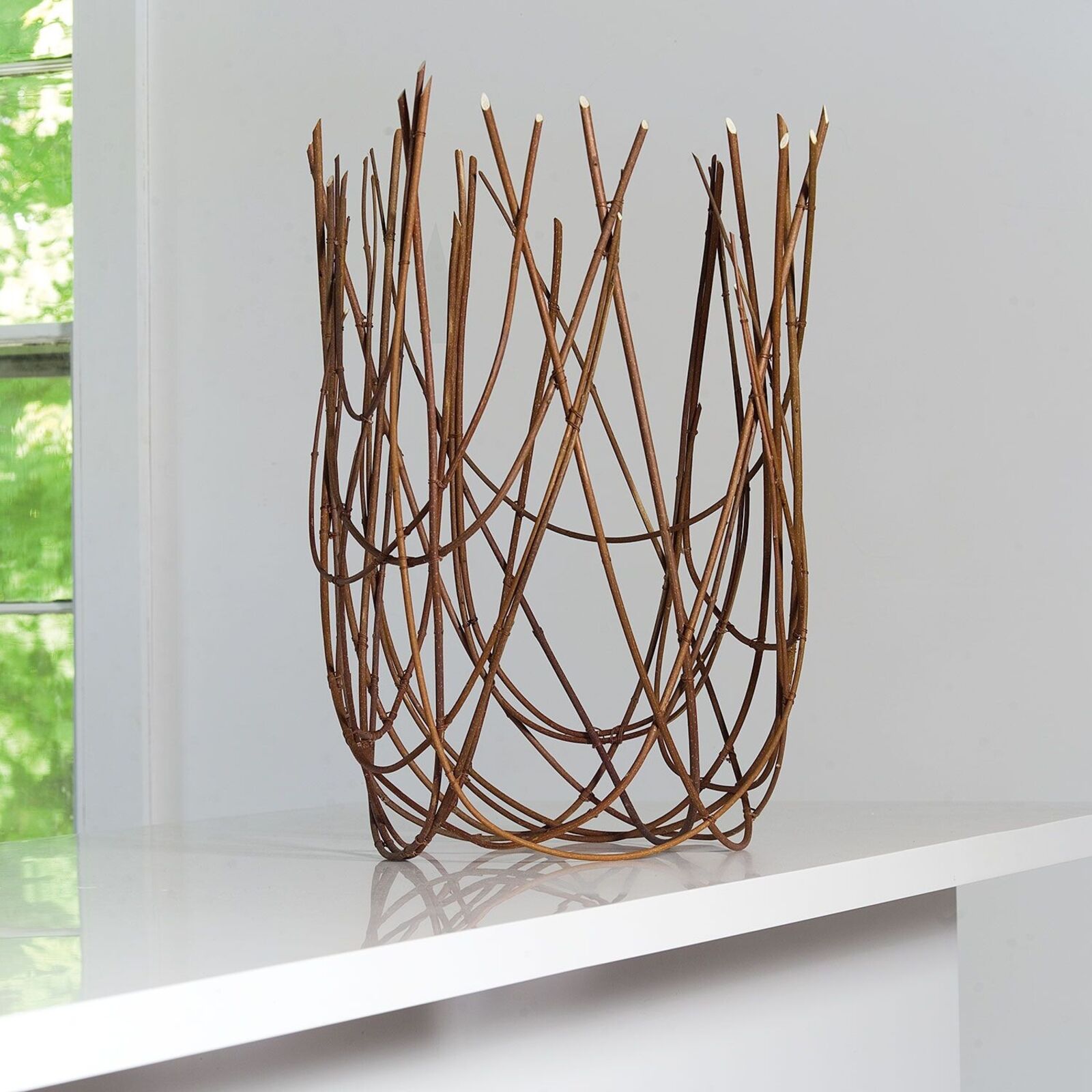 A vase that is sitting on top of a white shelf.