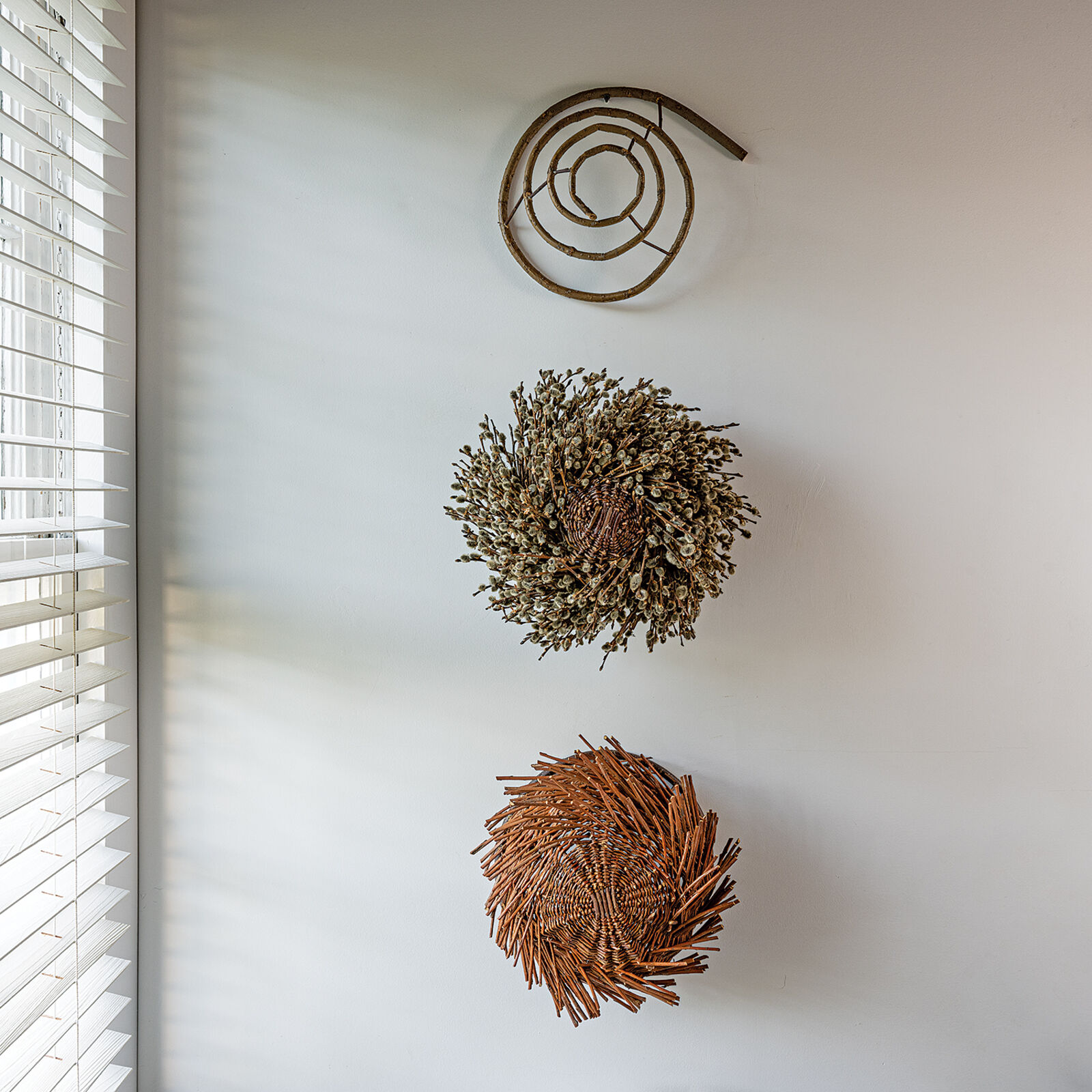 A basket filled with willow branches on top of a table.