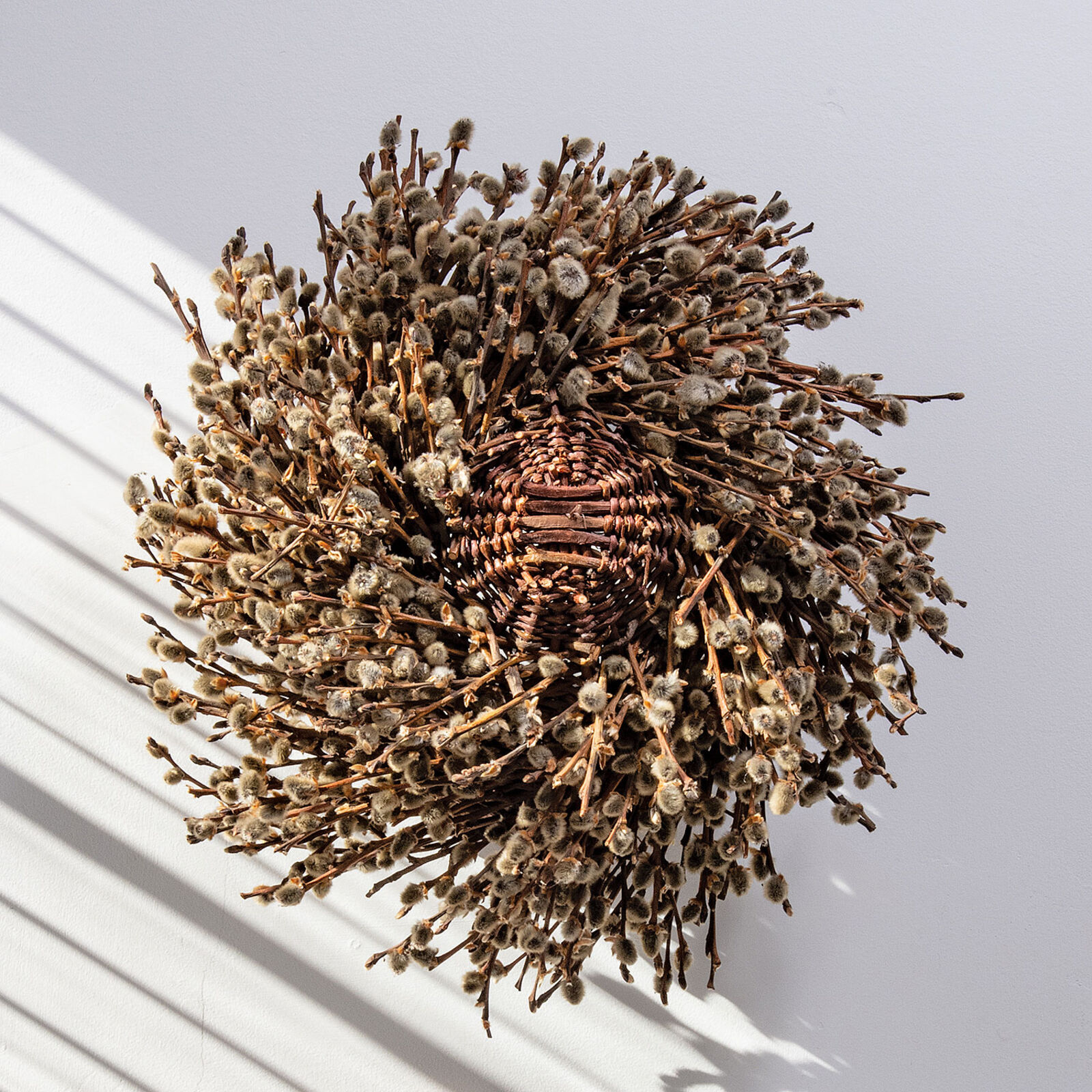 A basket filled with willow branches on top of a table.