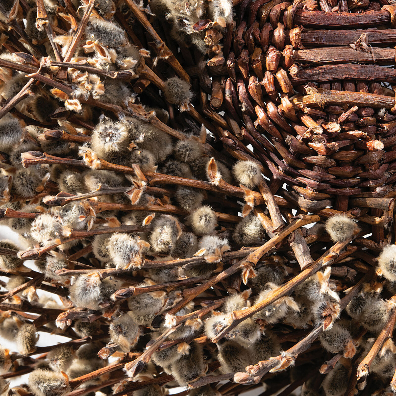 A basket filled with willow branches on top of a table.
