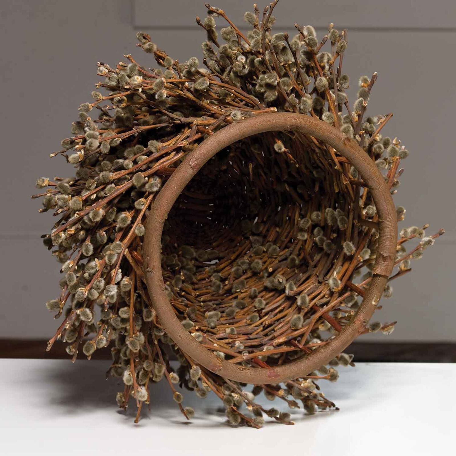 A basket filled with willow branches on top of a table.