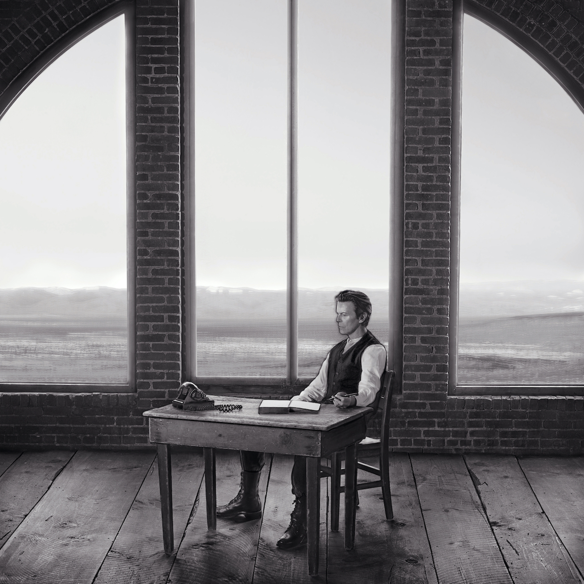 A man sitting at a desk in front of a window.