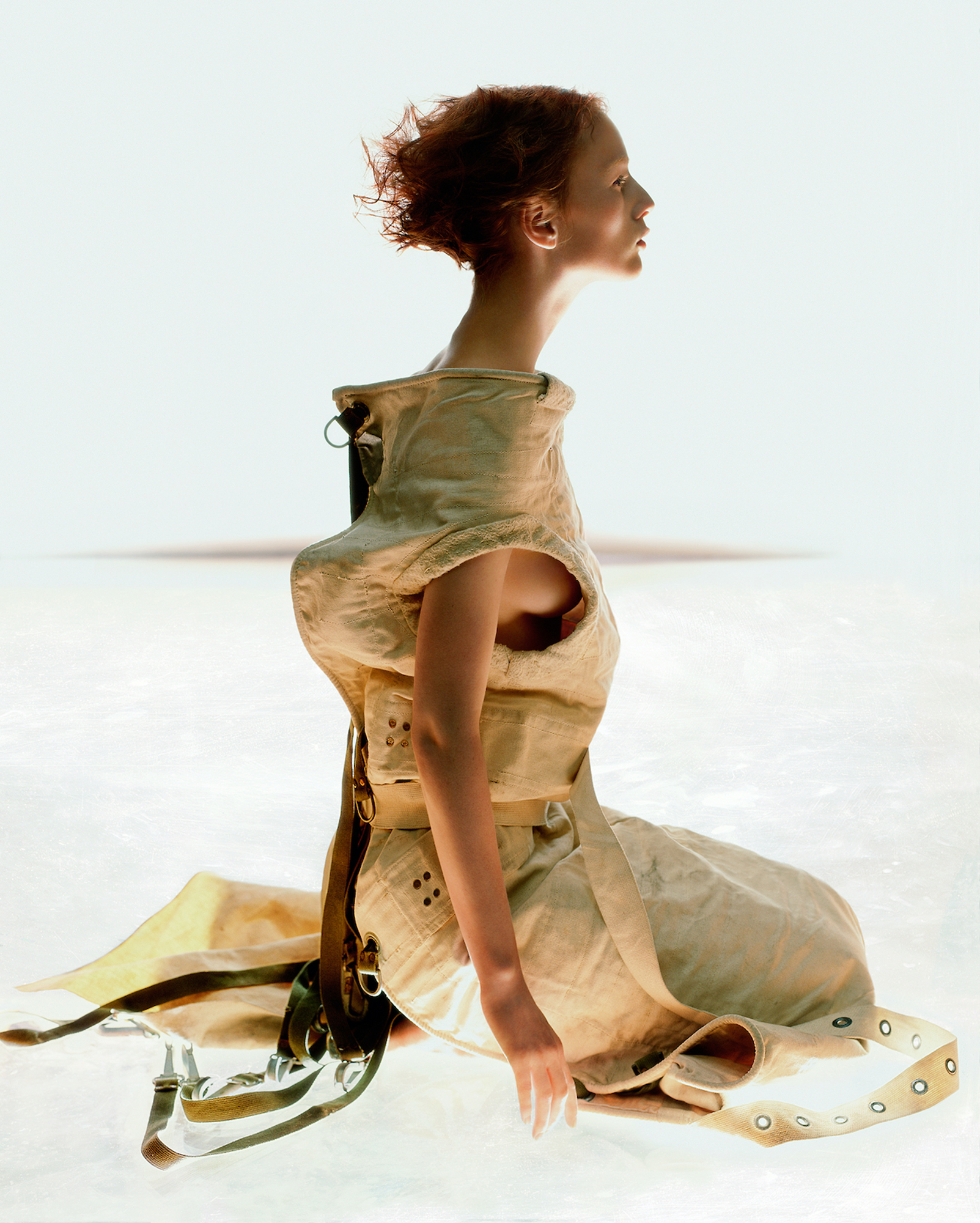 A woman in a dress sitting on the ground.