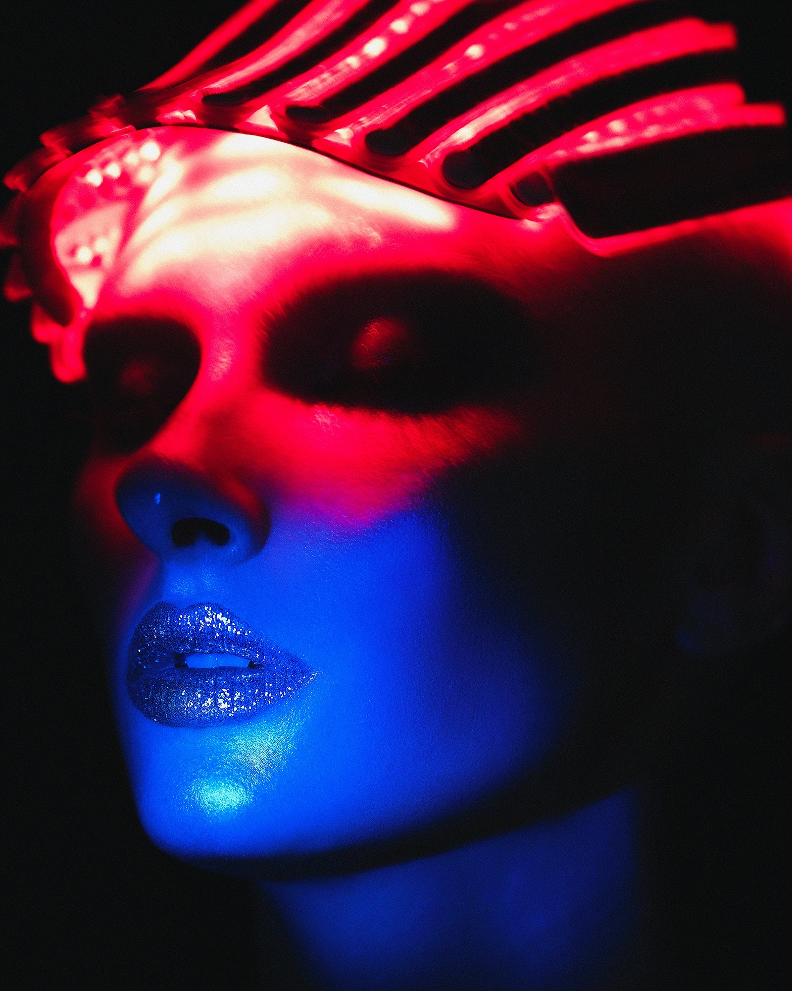 A woman with a red and blue light on her face.