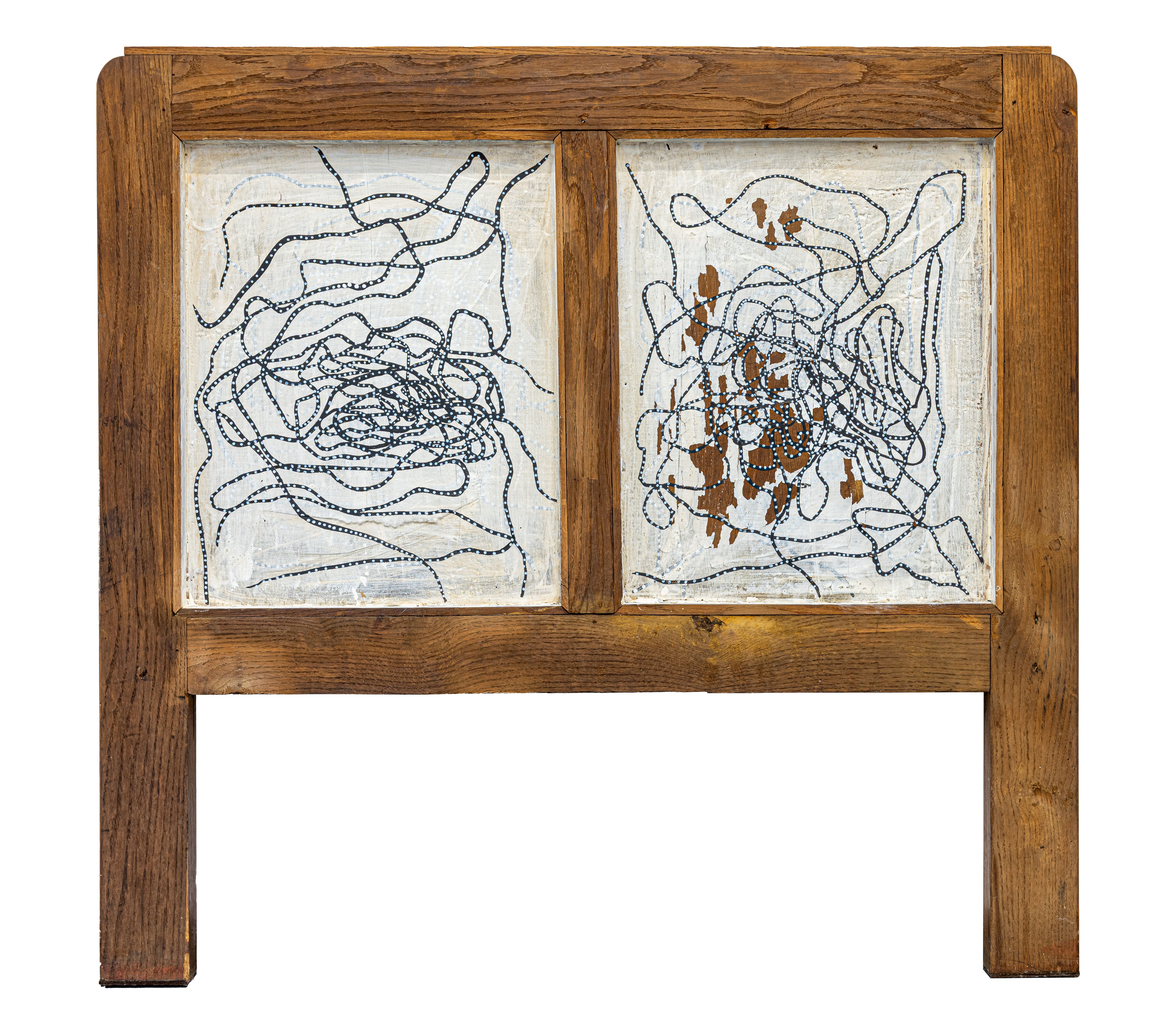 A wooden headboard with two paintings on it. 