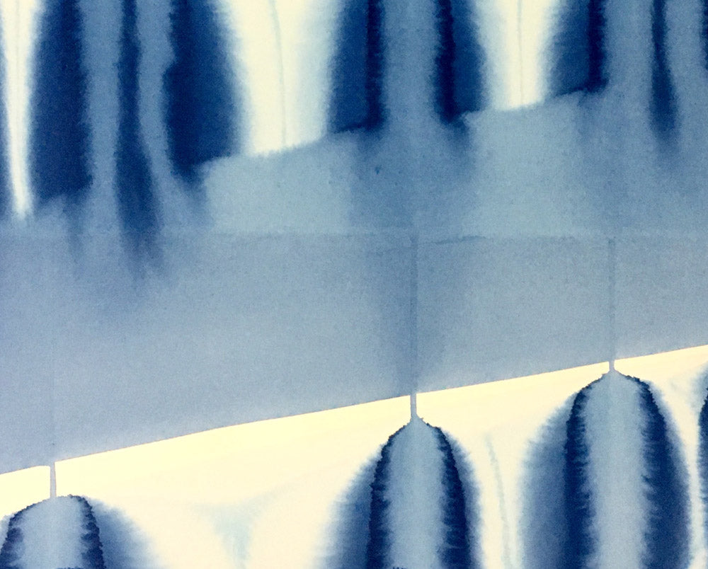 A blue and white painting on a white wall.