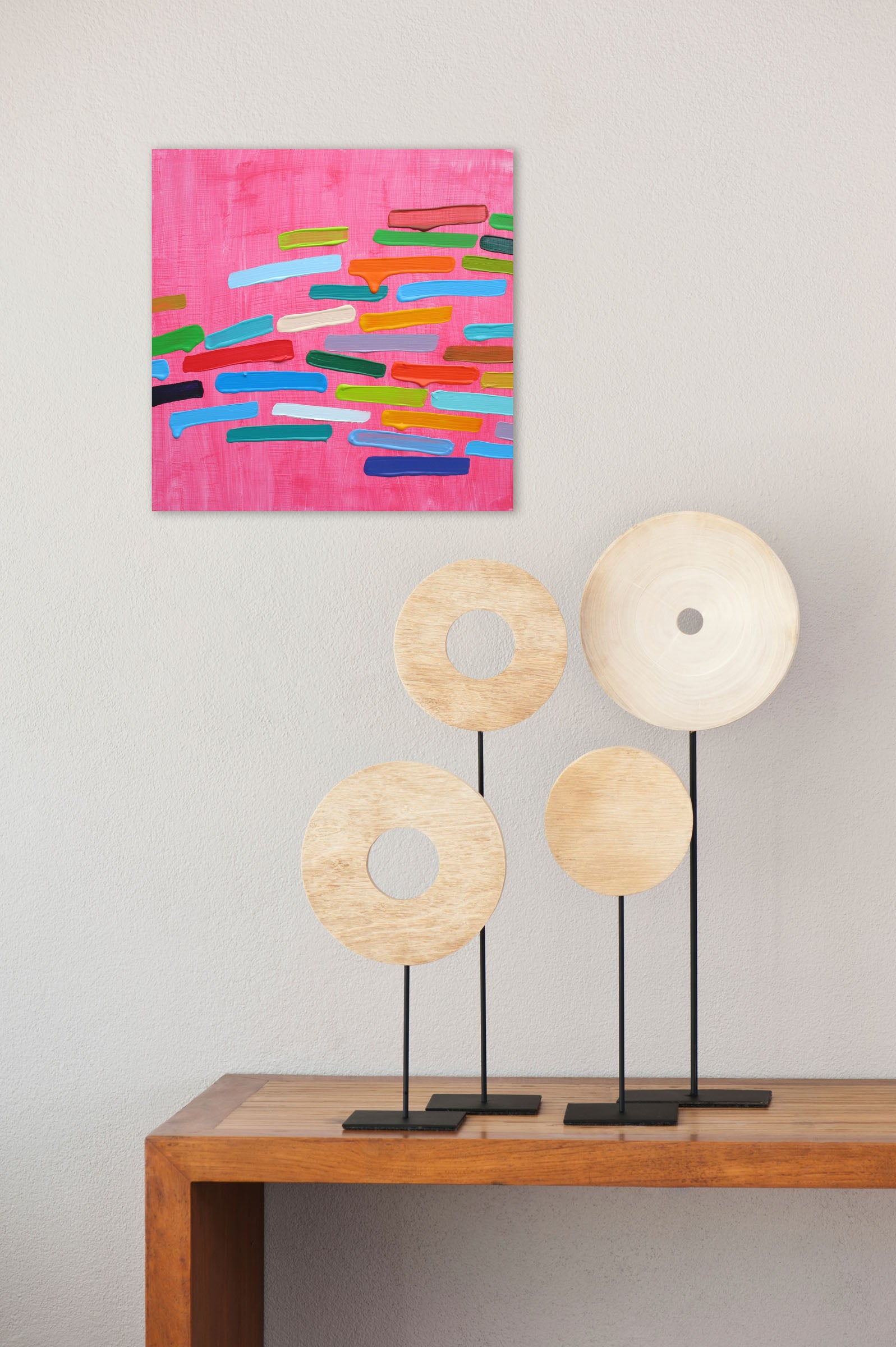 A painting of colorful paint strokes on a pink background.