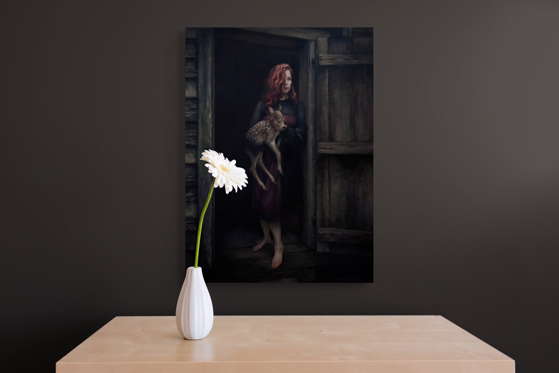 A woman holding a deer in a doorway.