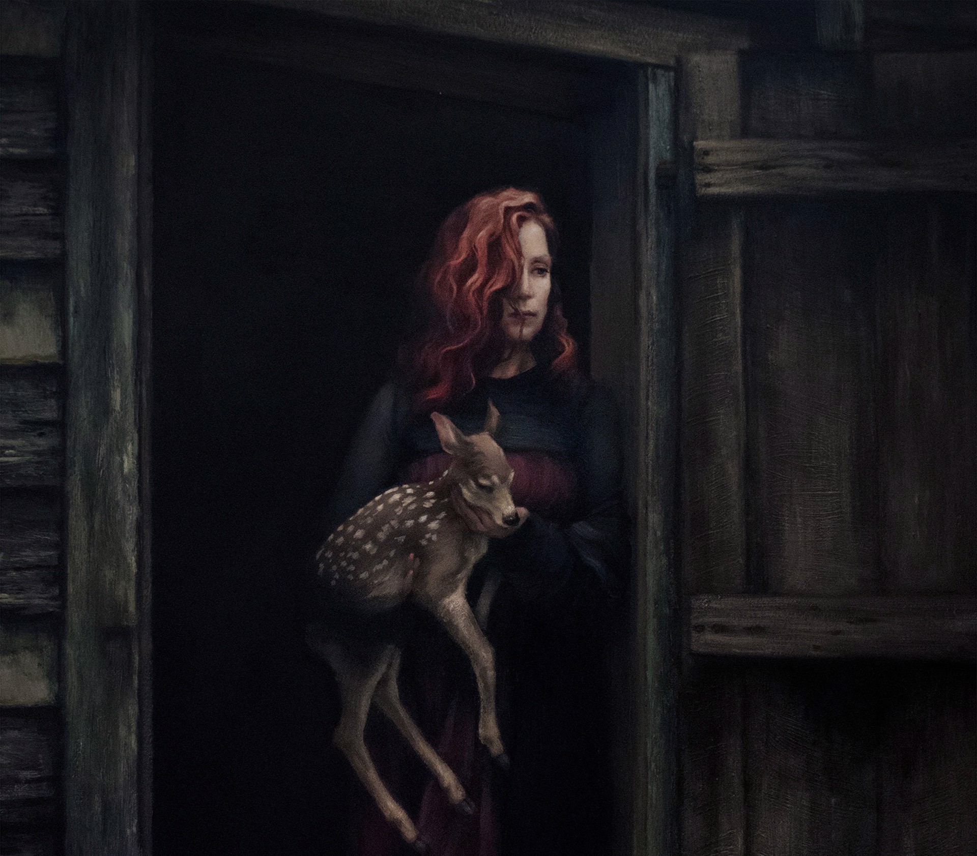 A woman holding a deer in a doorway.
