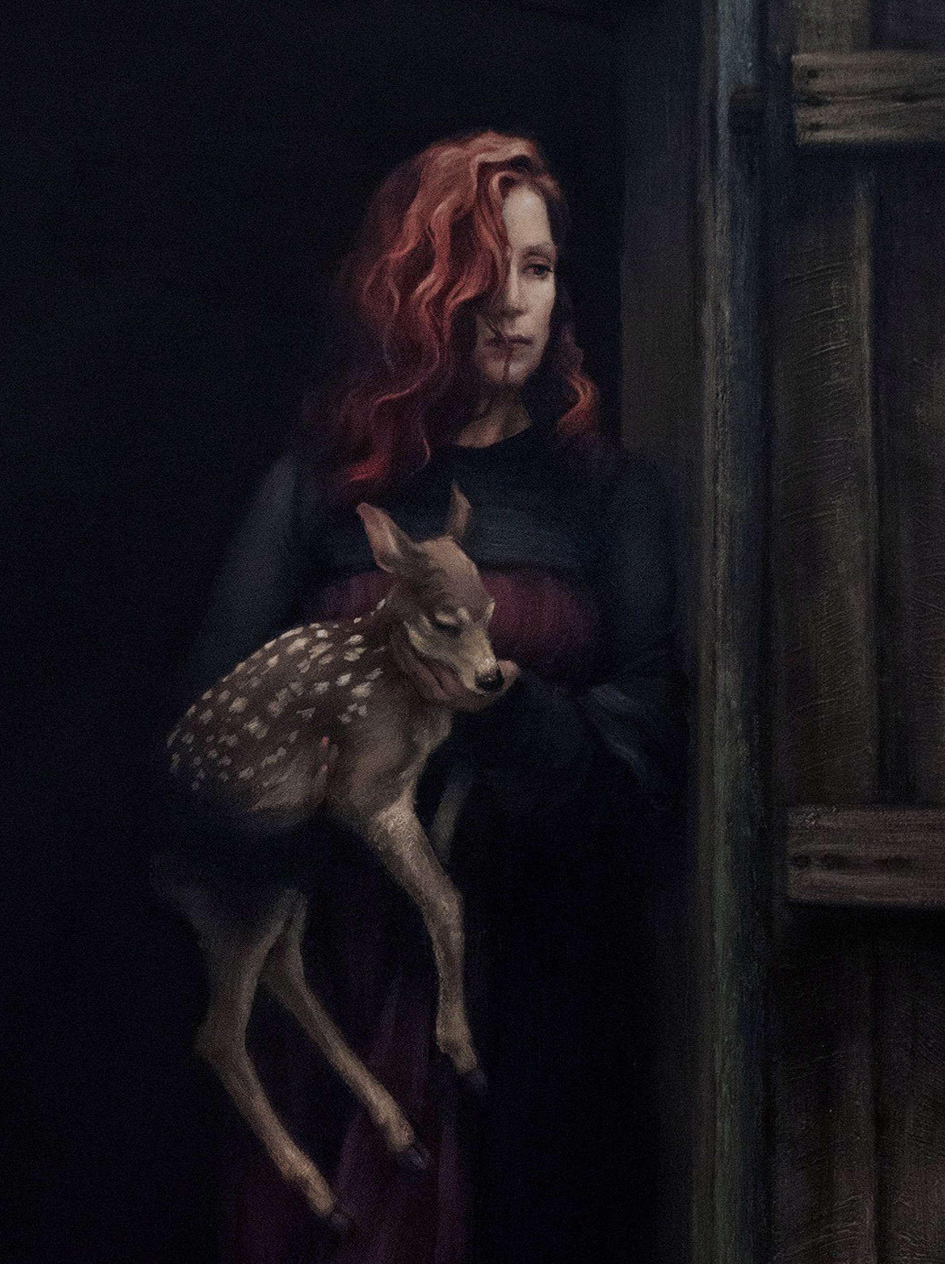 A woman holding a deer in a doorway.