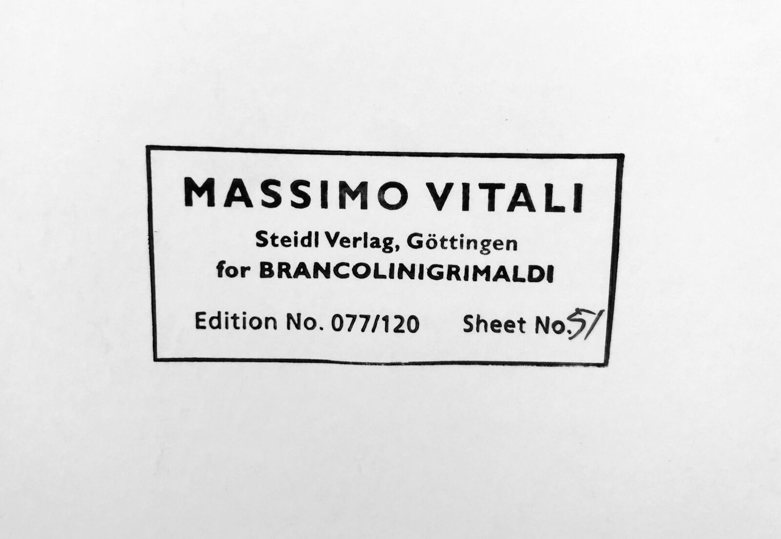 A large group of people sitting on top of a sandy beach.