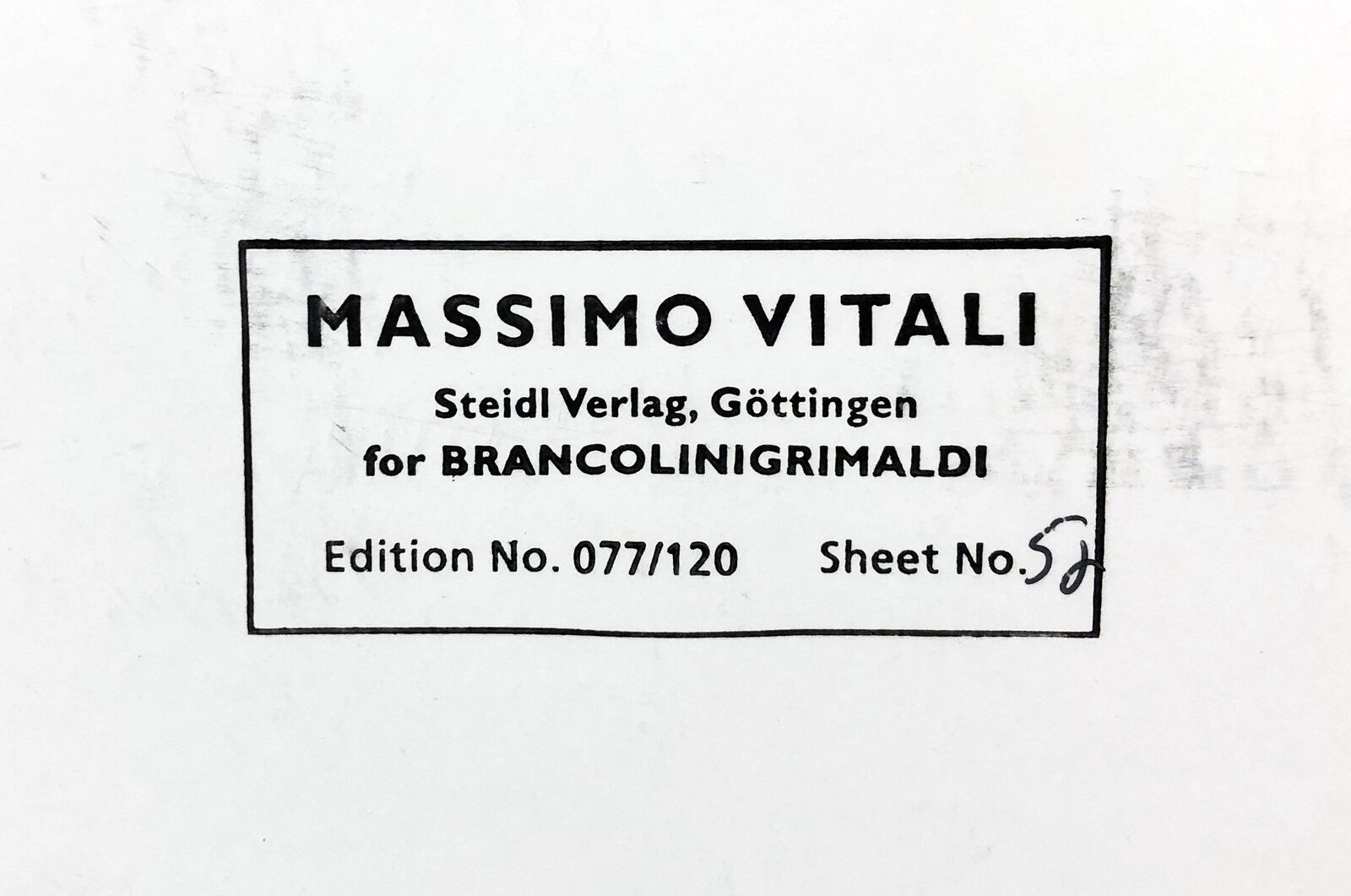 A large group of people sitting on top of a sandy beach.