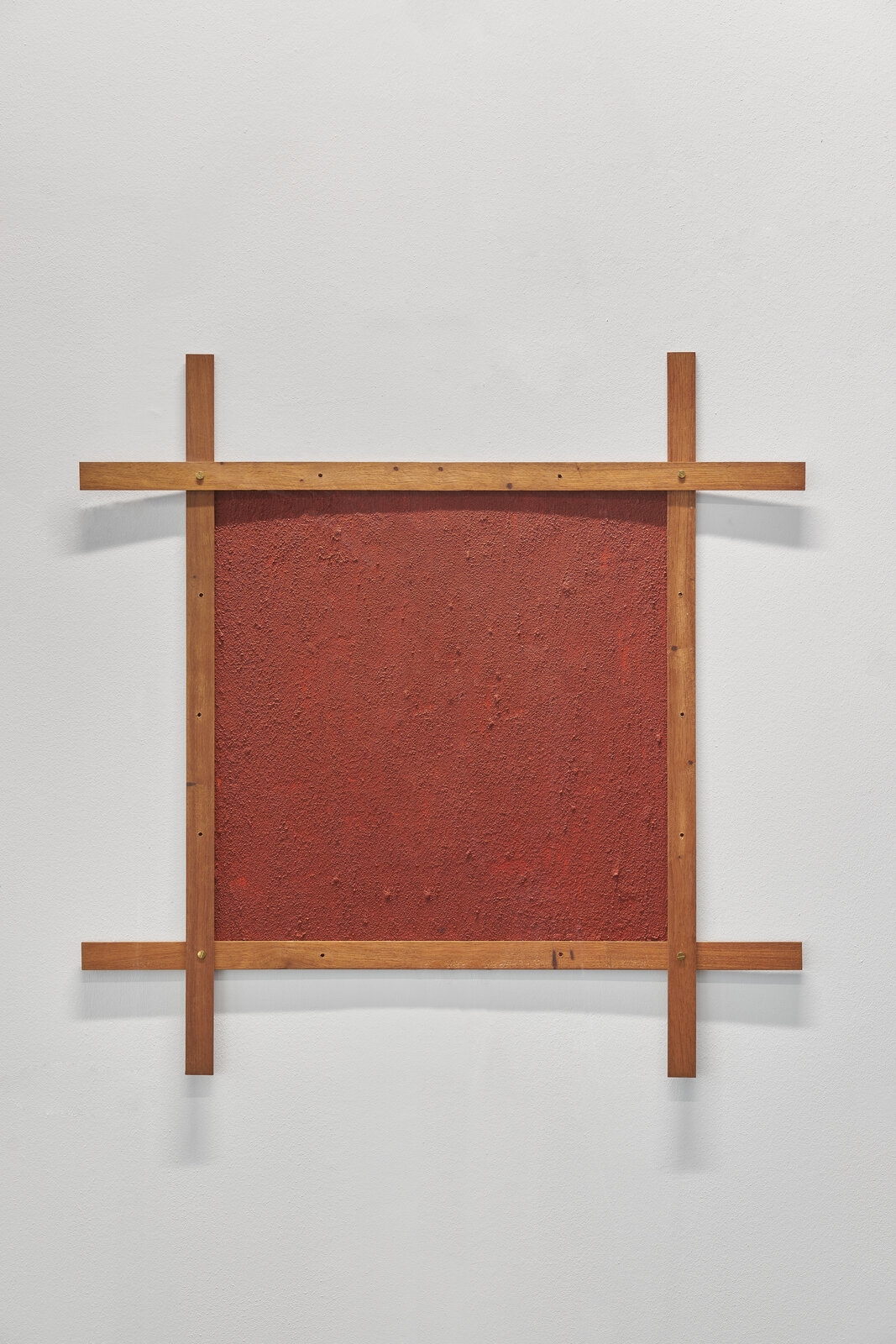 A red wall with a wooden frame on a white wall.