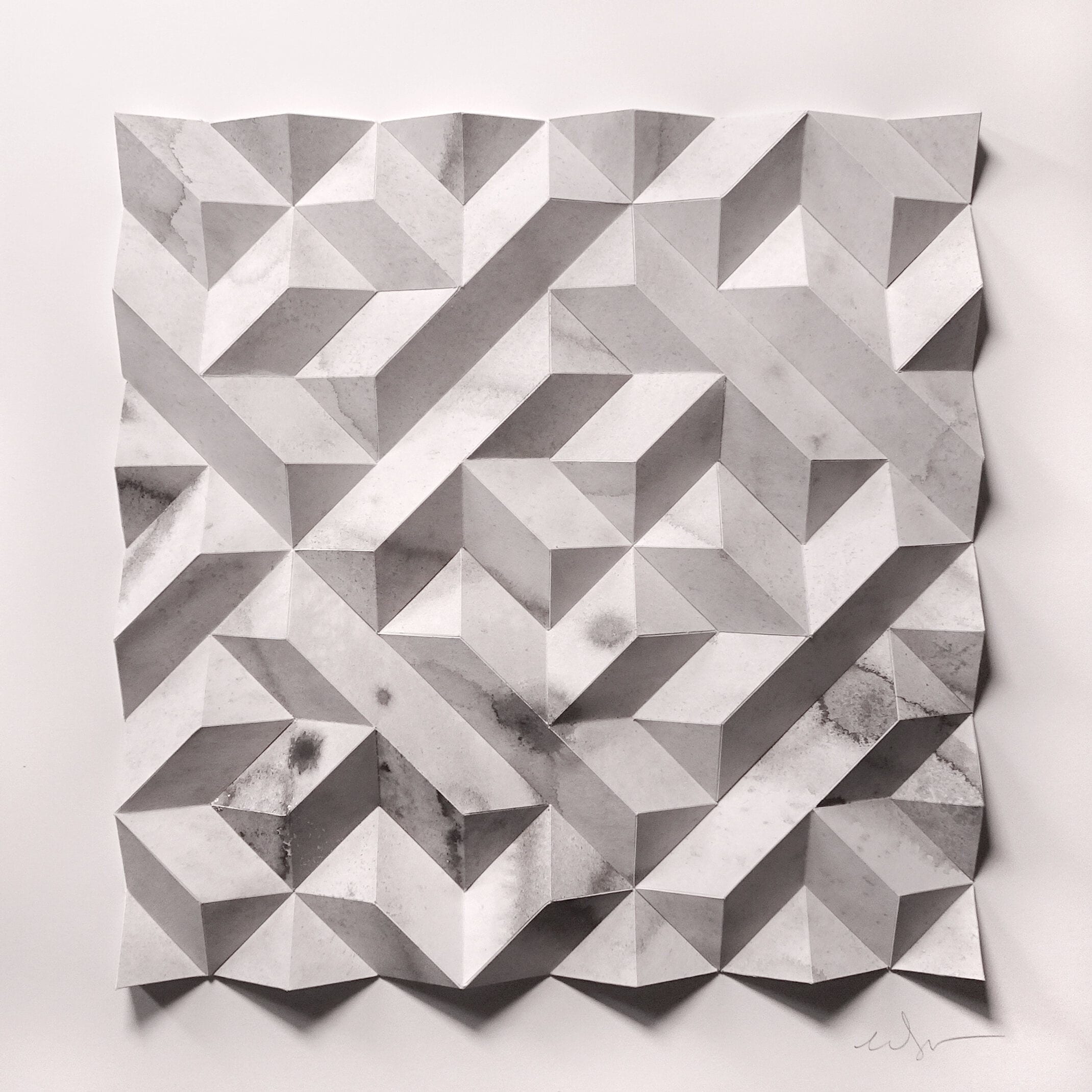 A black and white photo of a piece of paper that has been folded into a geometric pattern.