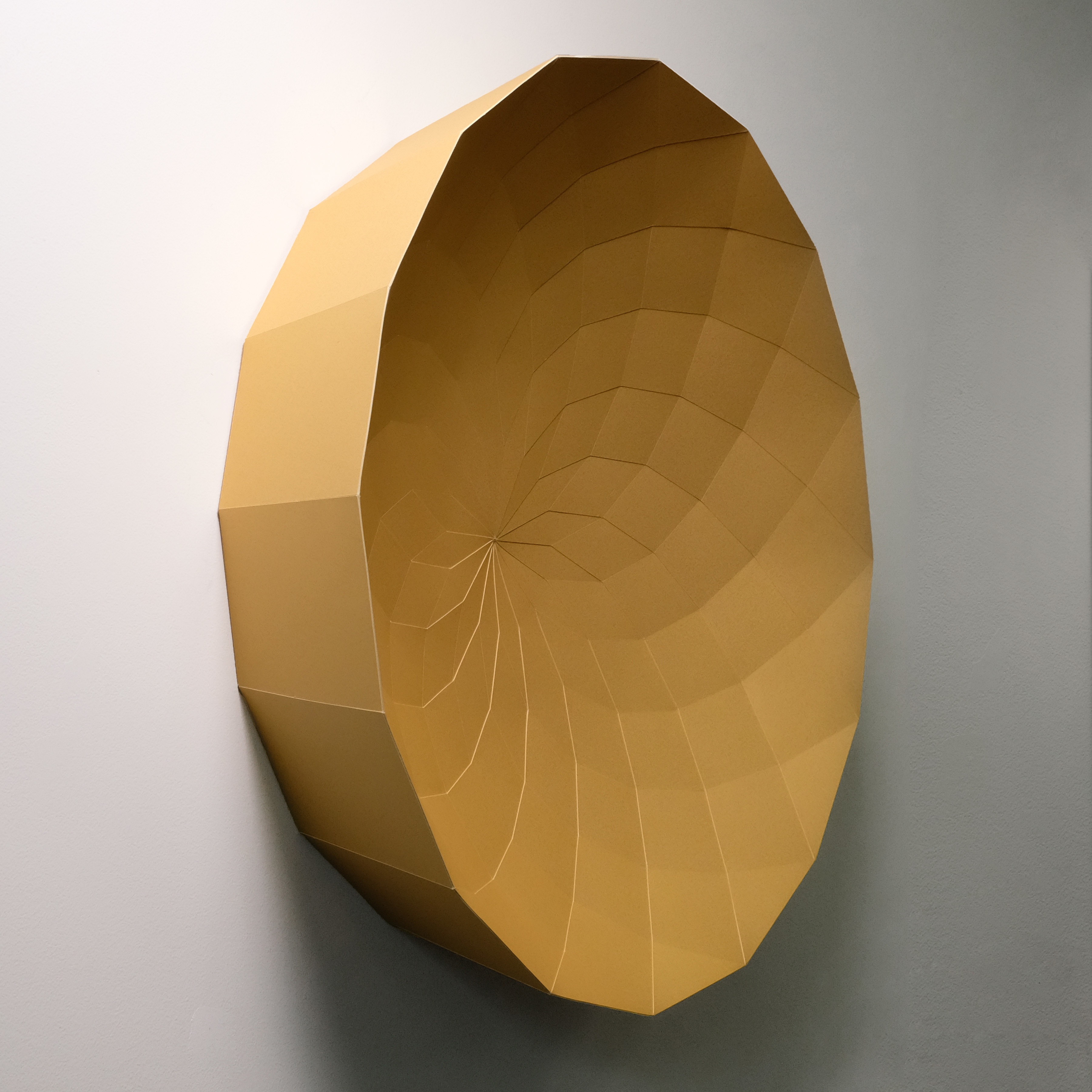 A 3D rendering of a golden sphere on a white wall.