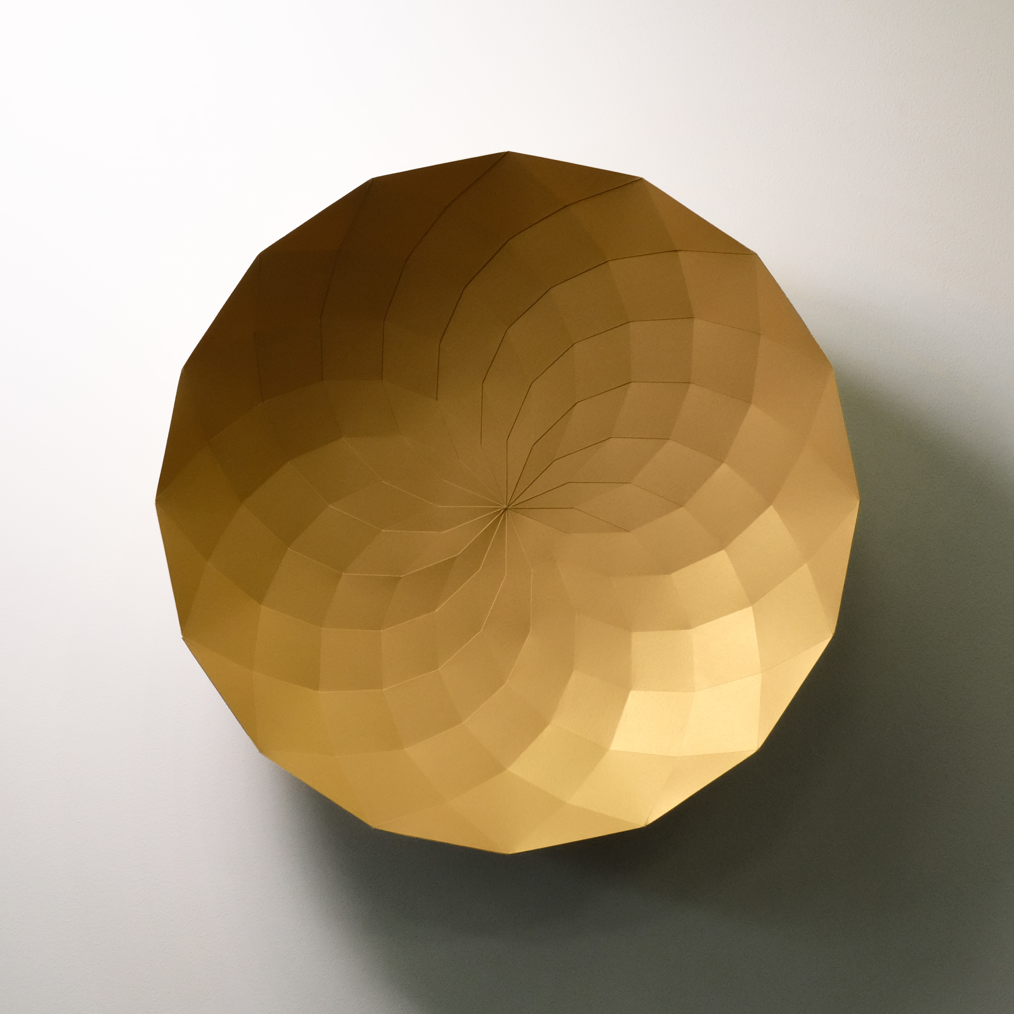 A 3D rendering of a golden sphere on a white wall.