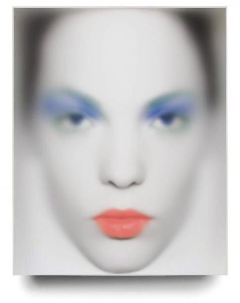 a woman with blue eyes and orange lipstick