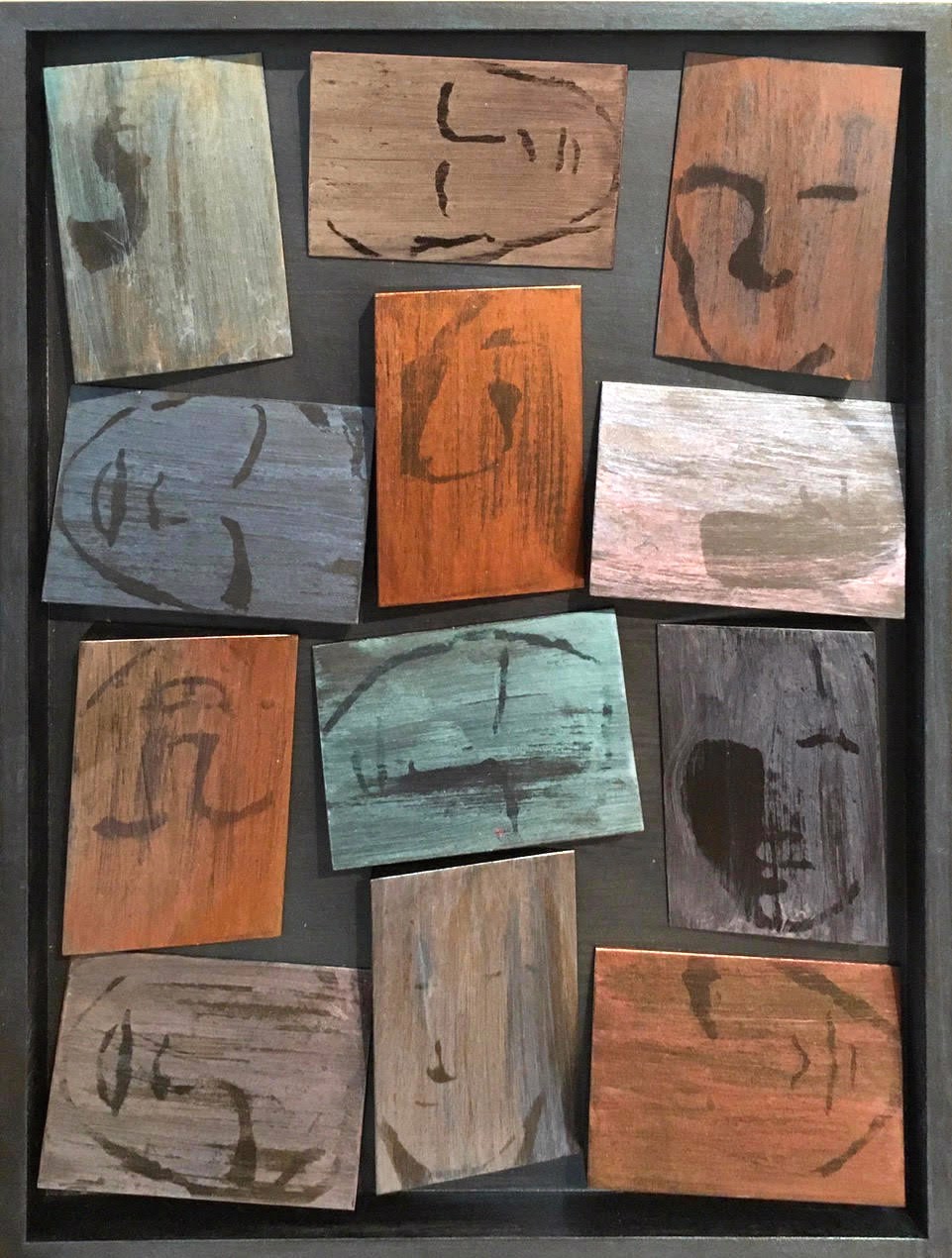 A picture of a group of wooden squares with faces drawn on them.