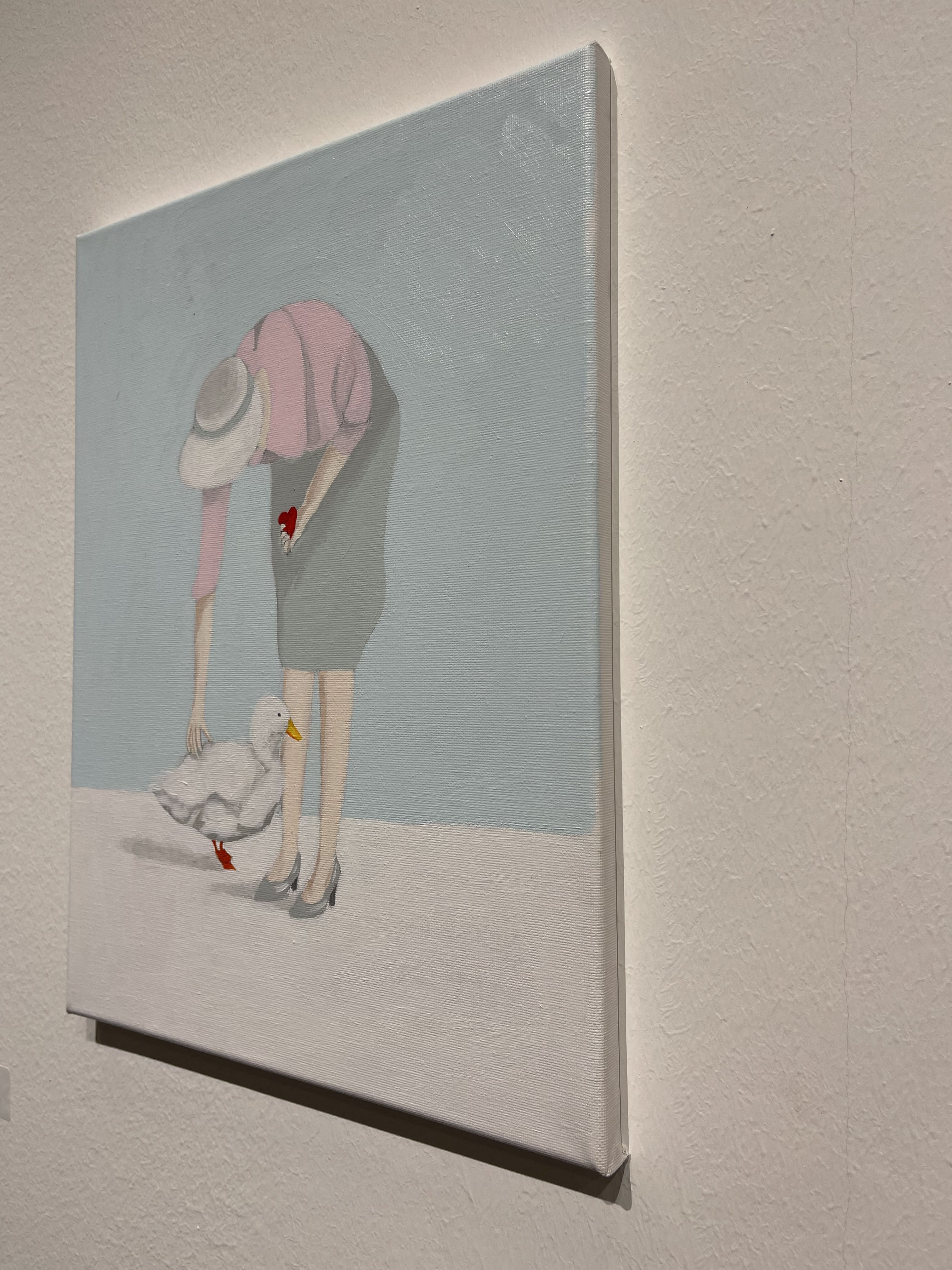 A painting of a woman feeding a duck with a heart.