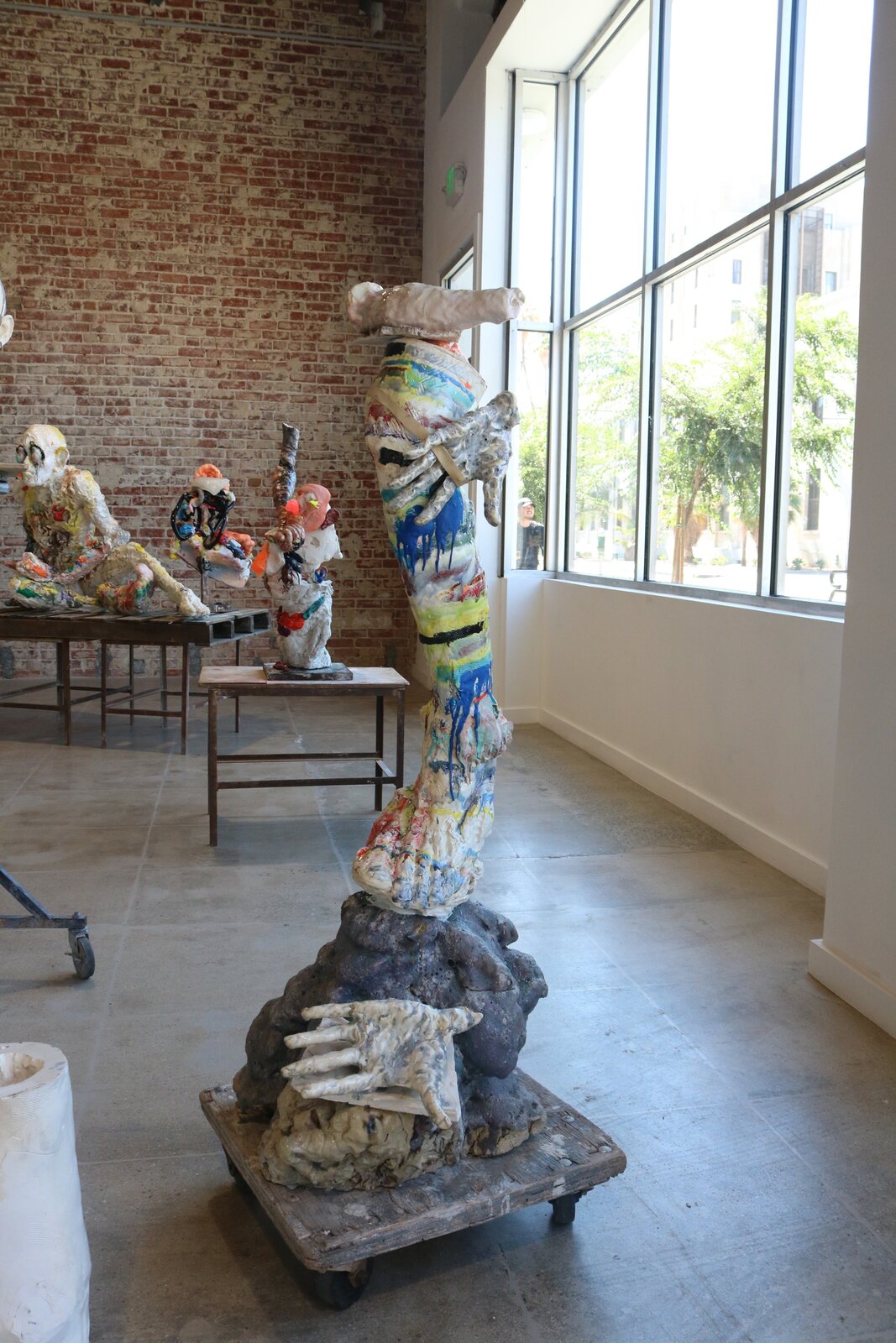 Artwork by Meghan Smythe, figures flanking a sacred tree, Made of Ceramic, Glaze, plasticine, epoxy, rubber band 