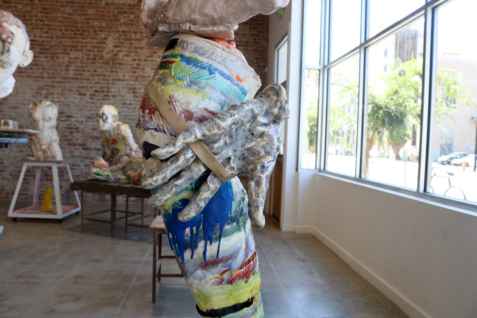 Artwork by Meghan Smythe, figures flanking a sacred tree, Made of Ceramic, Glaze, plasticine, epoxy, rubber band 