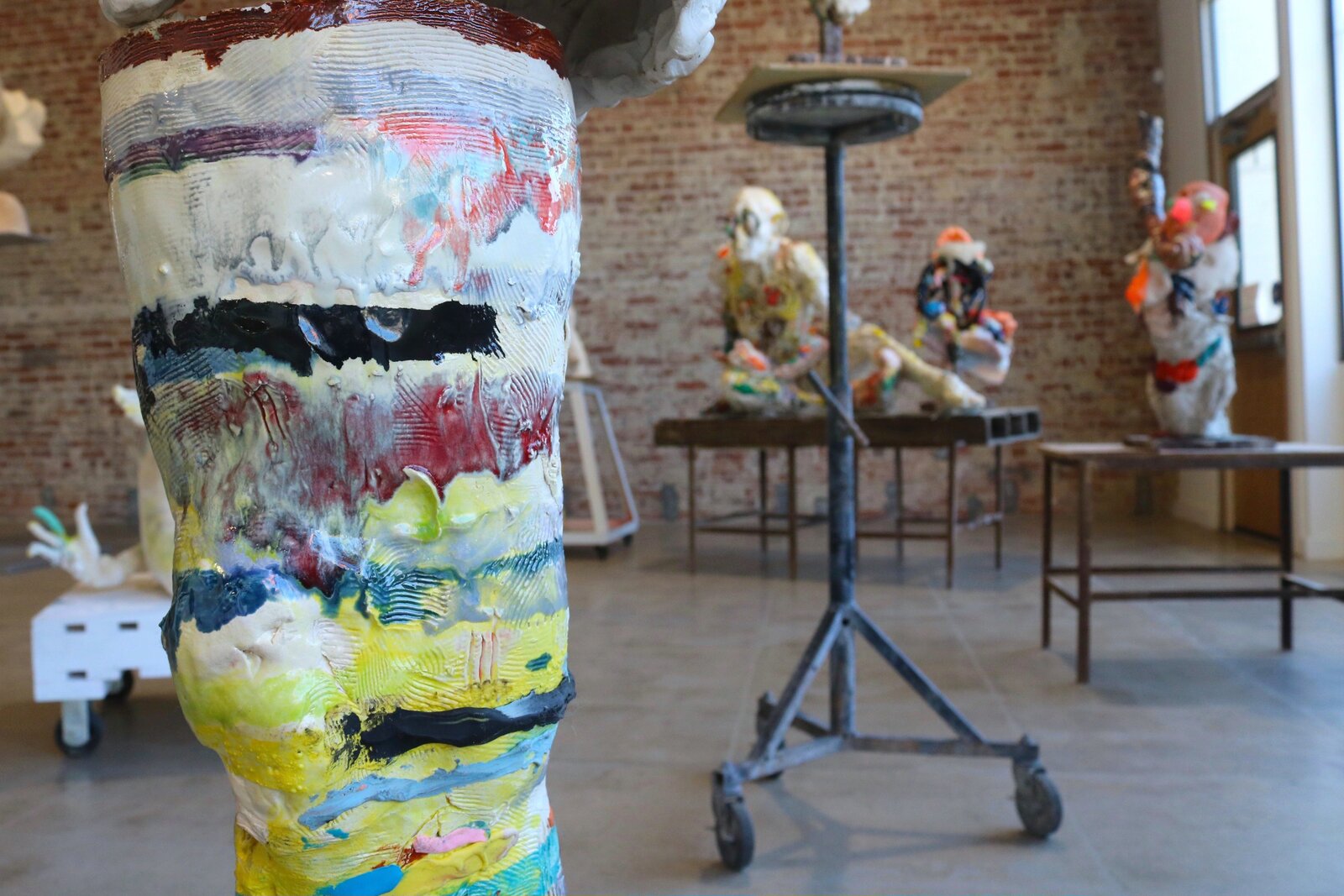 Artwork by Meghan Smythe, figures flanking a sacred tree, Made of Ceramic, Glaze, plasticine, epoxy, rubber band 