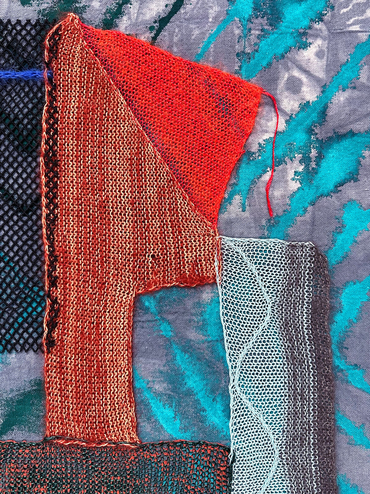 A textile collage featuring layered fabrics and abstract shapes.