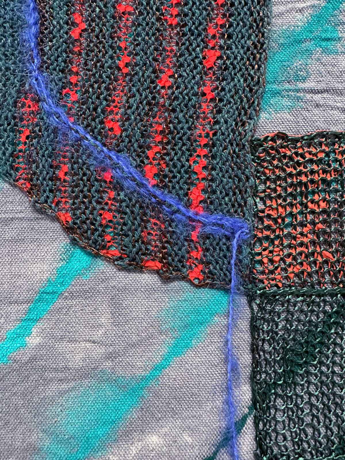 A textile collage featuring layered fabrics and abstract shapes.