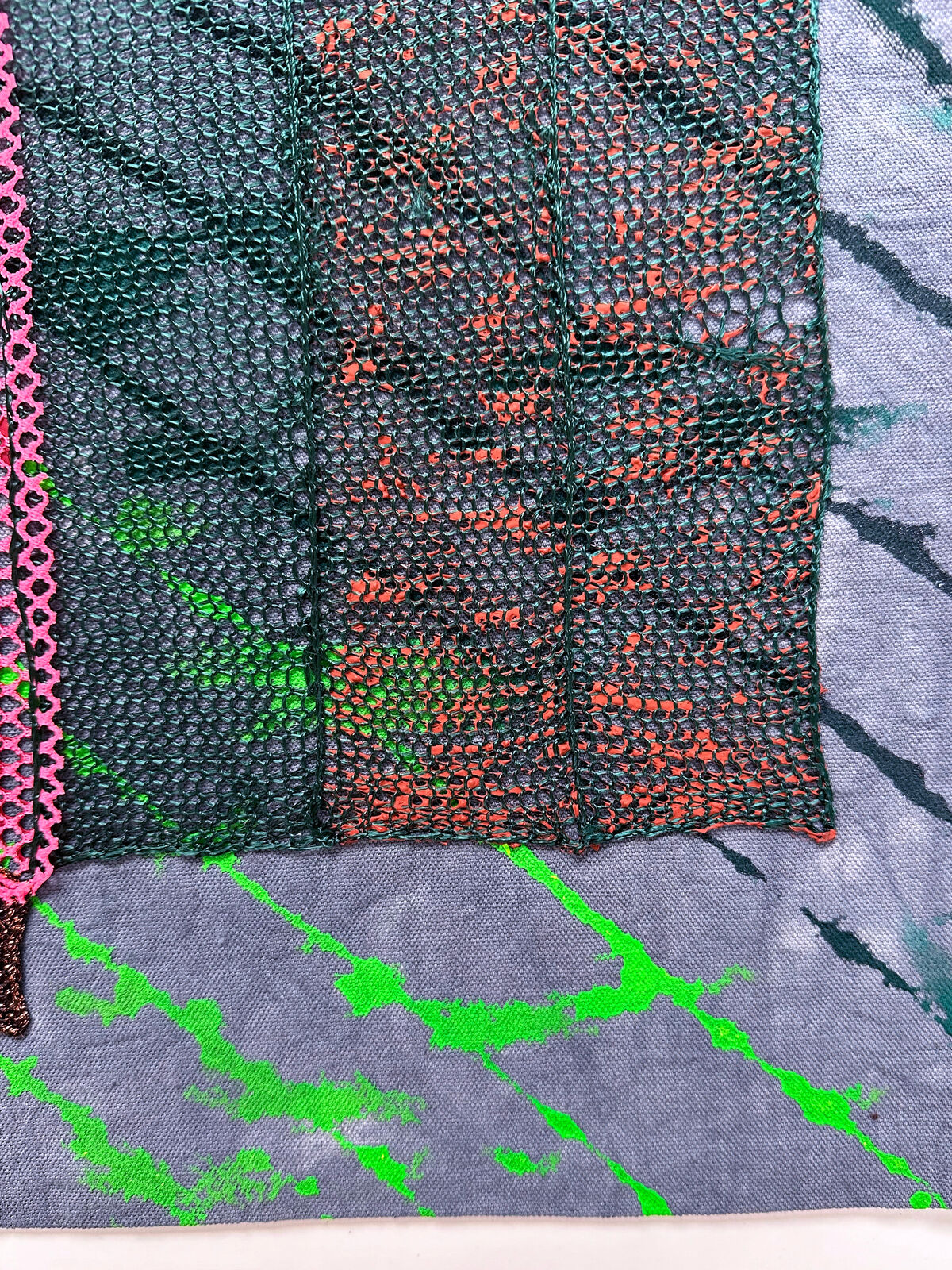 A textured textile artwork featuring a stylized face with vibrant colors and mixed media elements.