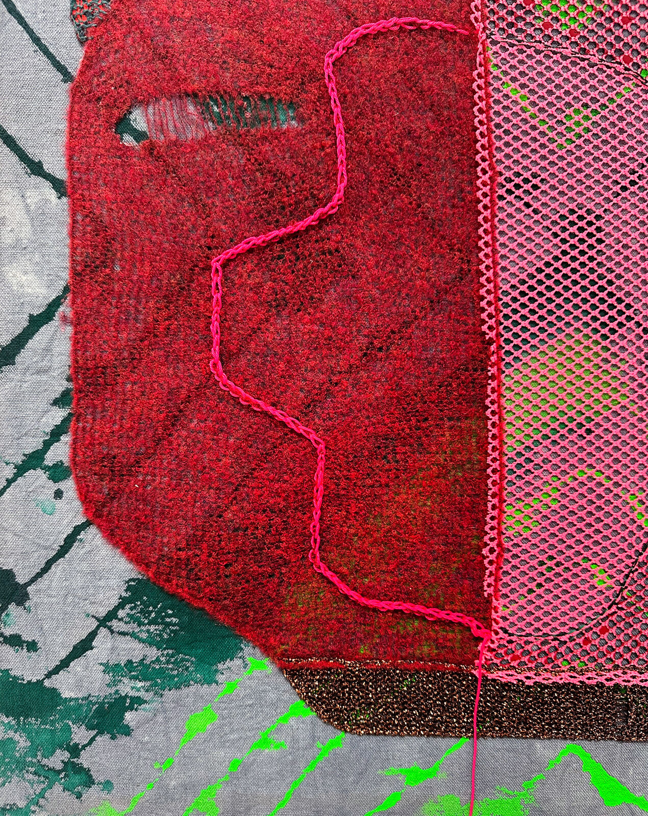 A textured textile artwork featuring a stylized face with vibrant colors and mixed media elements.