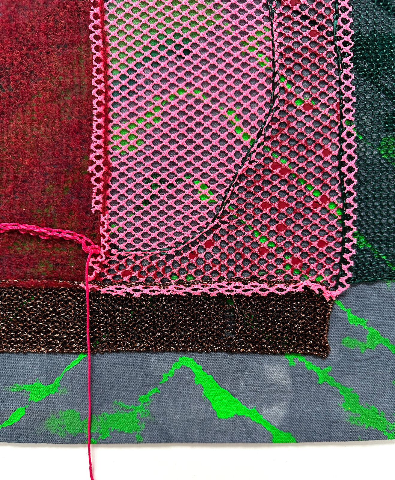 A textured textile artwork featuring a stylized face with vibrant colors and mixed media elements.