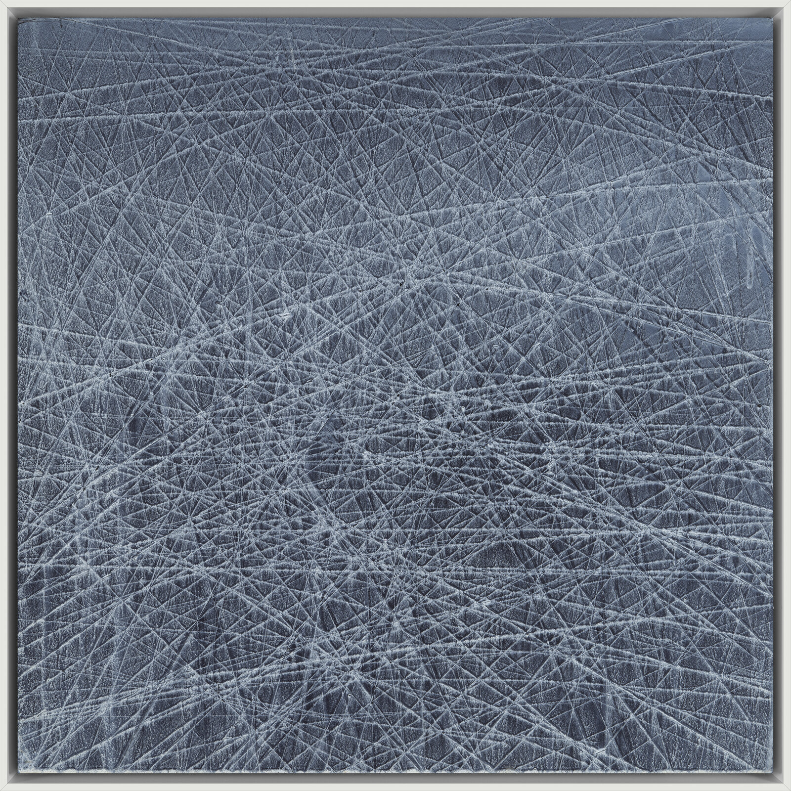 A textured abstract composition of a grey surface covered in a dense network of white scratches.