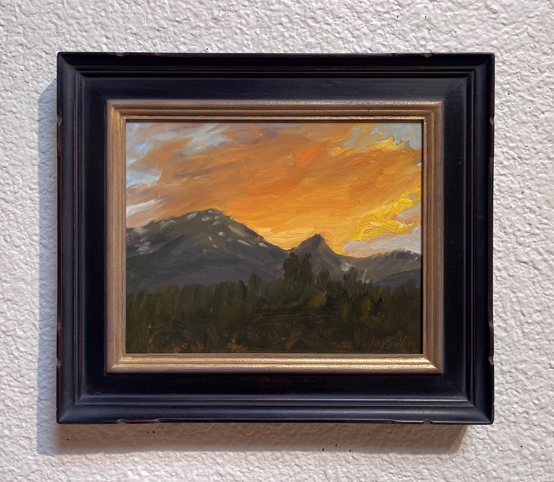 A painting of a sunset over a mountain range.