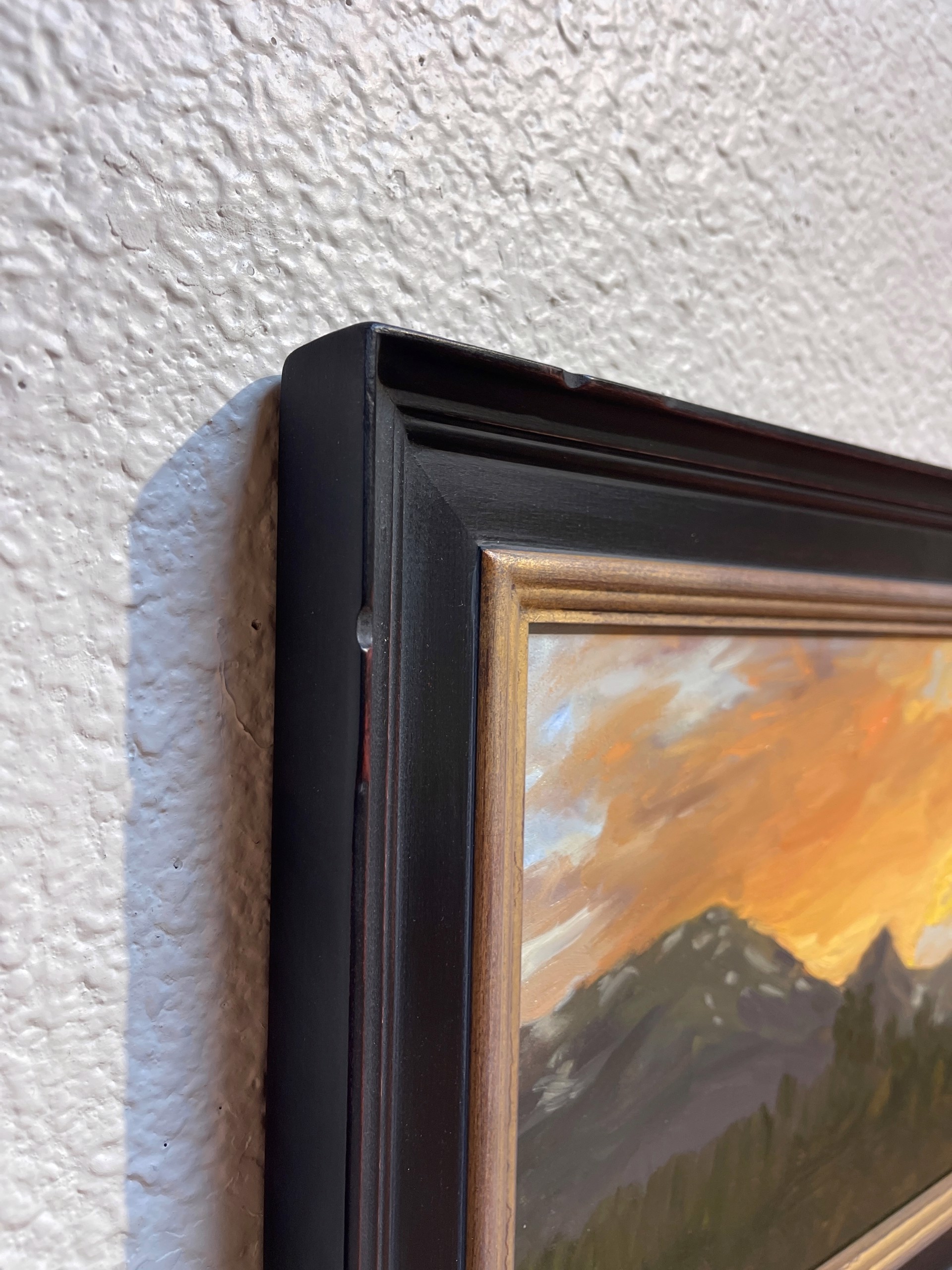 A painting of a sunset over a mountain range.